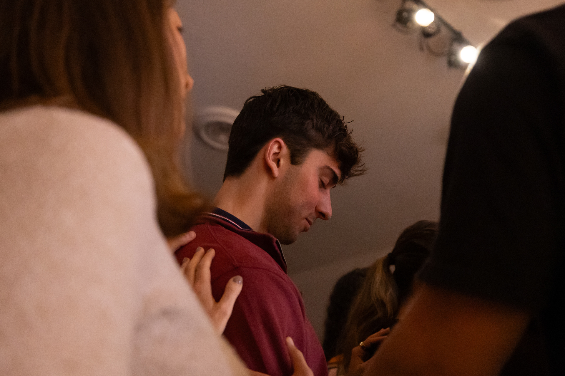 Jason Thisdale, a UGA senior who started going to church his sophomore year, receives prayer at Wesley Chapel in Athens, Georgia on Wednesday, Nov. 12, 2025. Thisdale was surrounded by people in support of him after he went to the front to profess his faith in Christ. (Photo/Evan Frilingos)