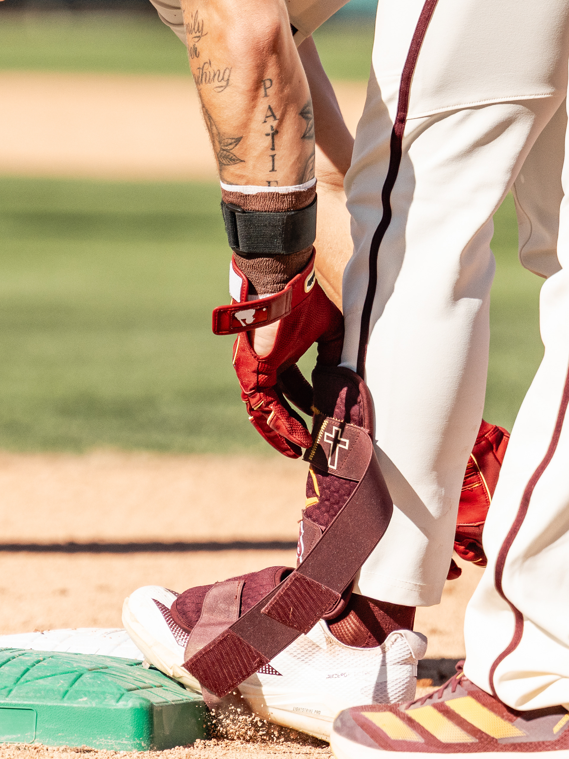Beckett Zavorek, Arizona State University infielder, takes off his shin pad after reaching first base during a home game against St. John’s University at Phoenix Municipal Stadium on Sunday, February 22, 2026 in Phoenix, Arizona. 