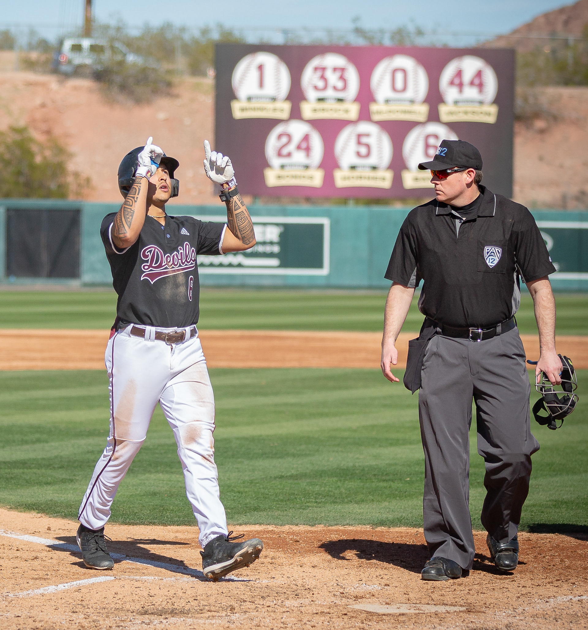 Nu’u Contrades, Arizona State University infielder, points to the sky before touching home plate after hitting a homerun during a game at Phoenix Municipal Stadium on Saturday, February 17, 2024 in Phoenix, Arizona. 