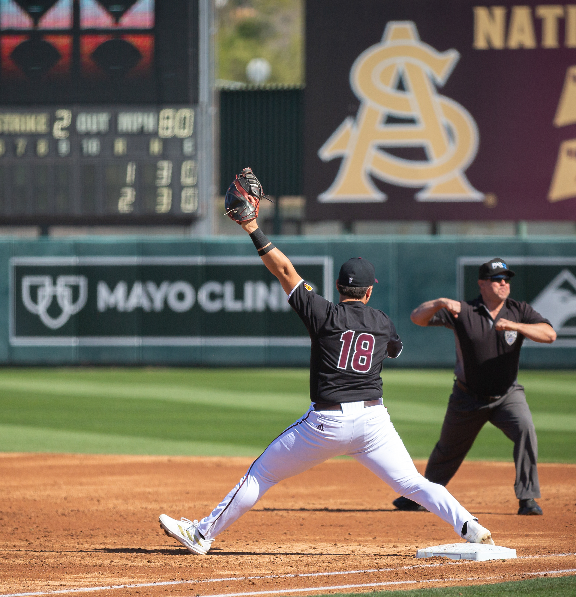  Jacob Tobias, Arizona State University infielder,  stretches for the ball and looks at the umpire for the call during a game at Phoenix Municipal Stadium on Saturday, February 24, 2024 in Phoenix, Arizona.