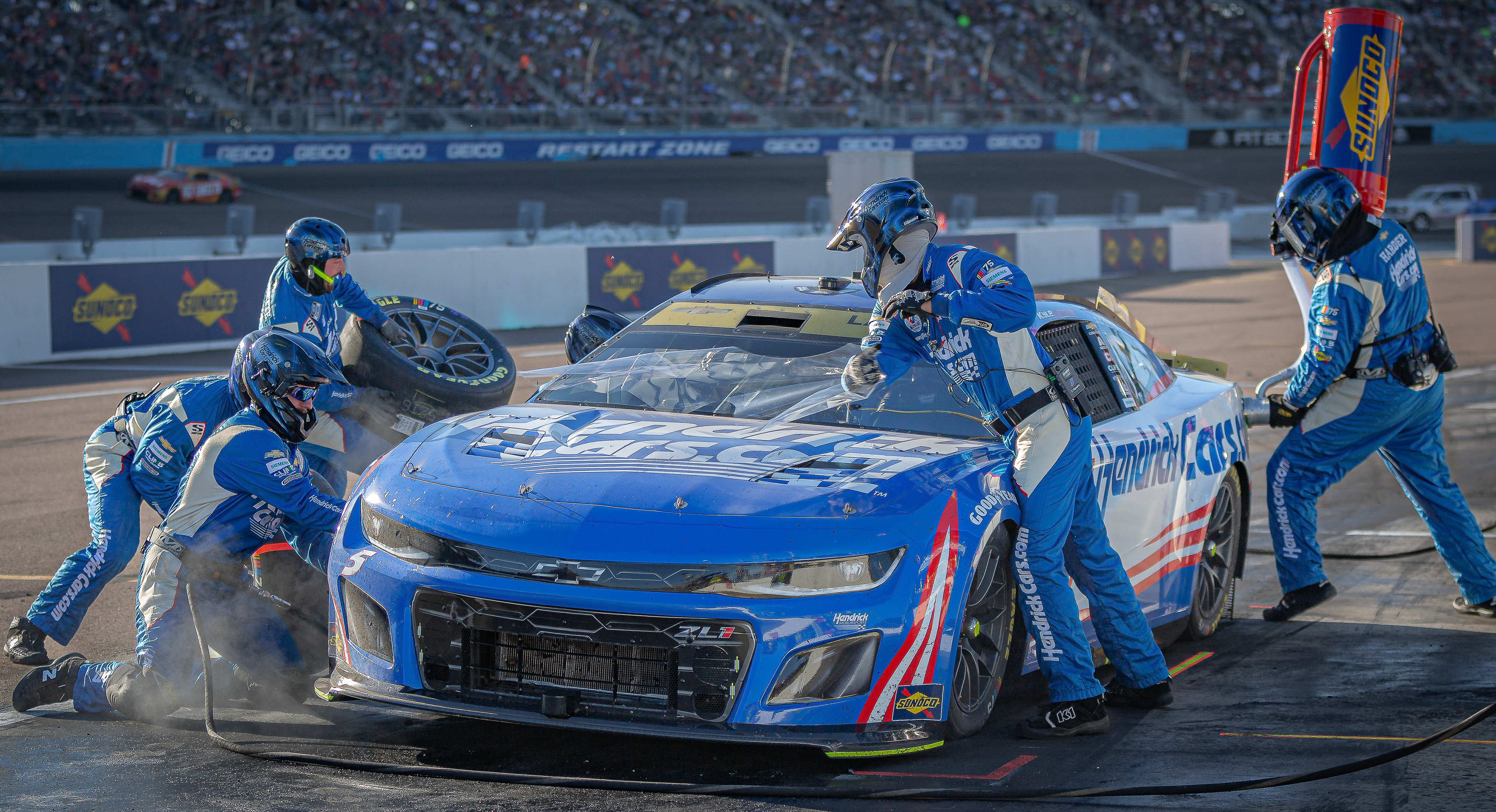 Kyle Larson's pit crew works on his car changing tires and giving gas during a pit stop at Phoenix Raceway on Sunday, November 5, 2024 in Avondale, Arizona.