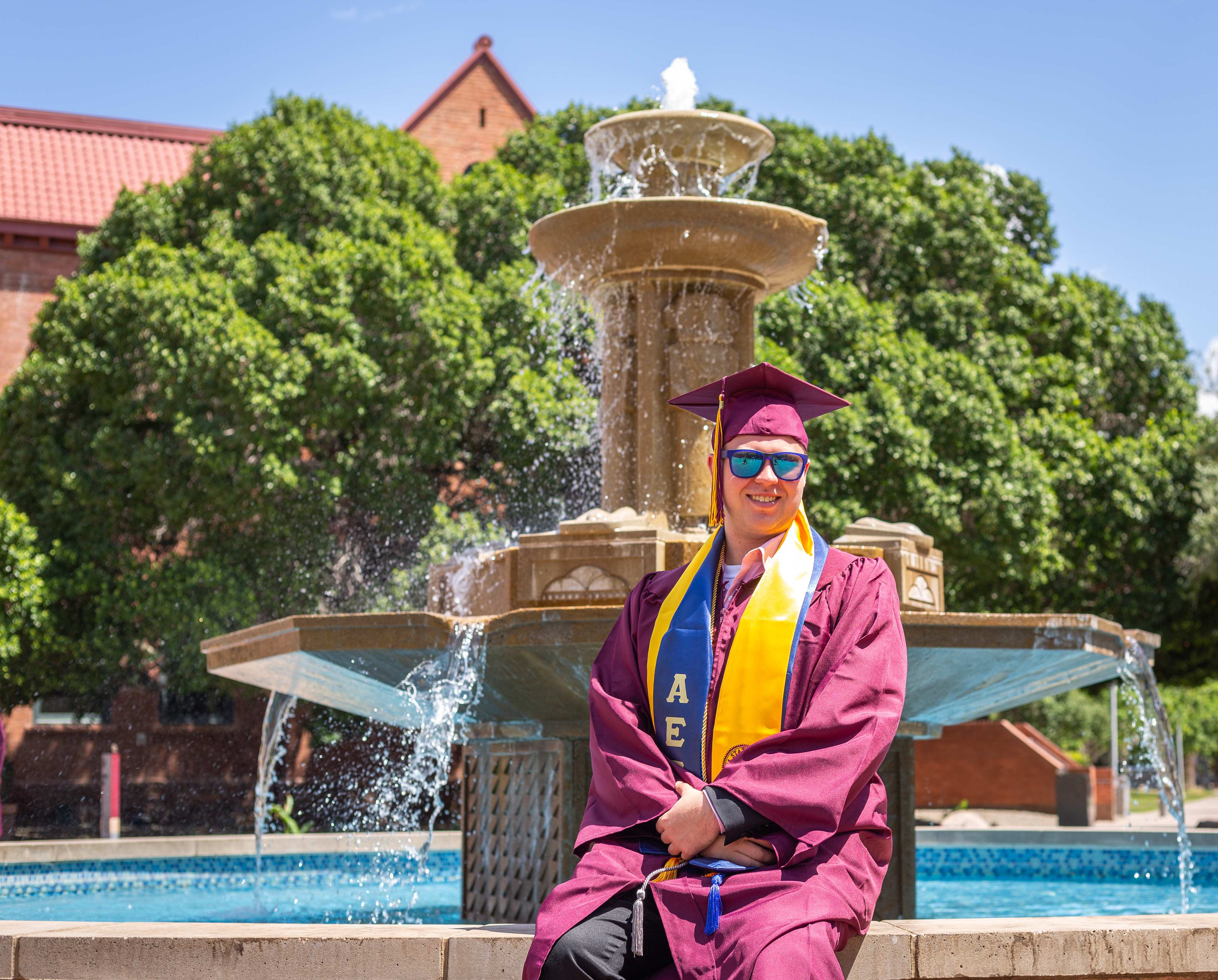  Tyler Baum, Arizona State University graduate, poses with the fountain outside of Old Main in Tempe, Arizona. 