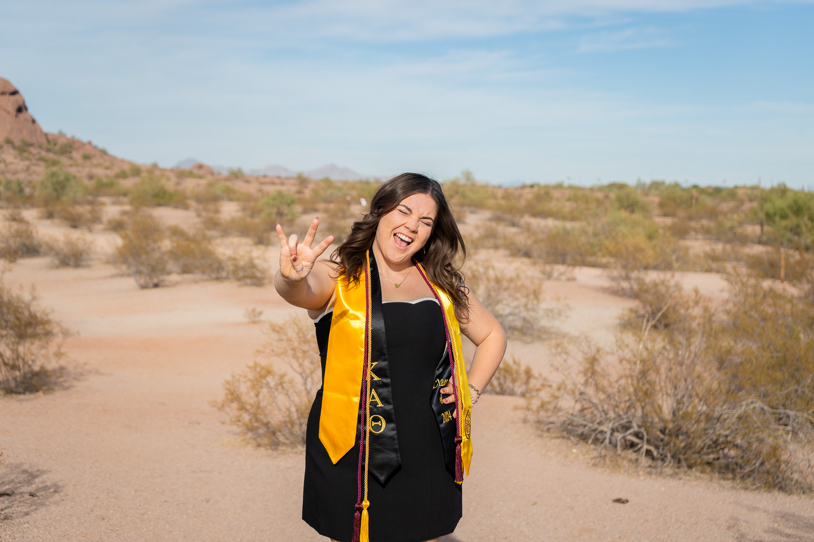Kaitlyn Wolfe, Arizona State University graduate, does the “forks up” sign at Papago Park in Phoenix, Arizona