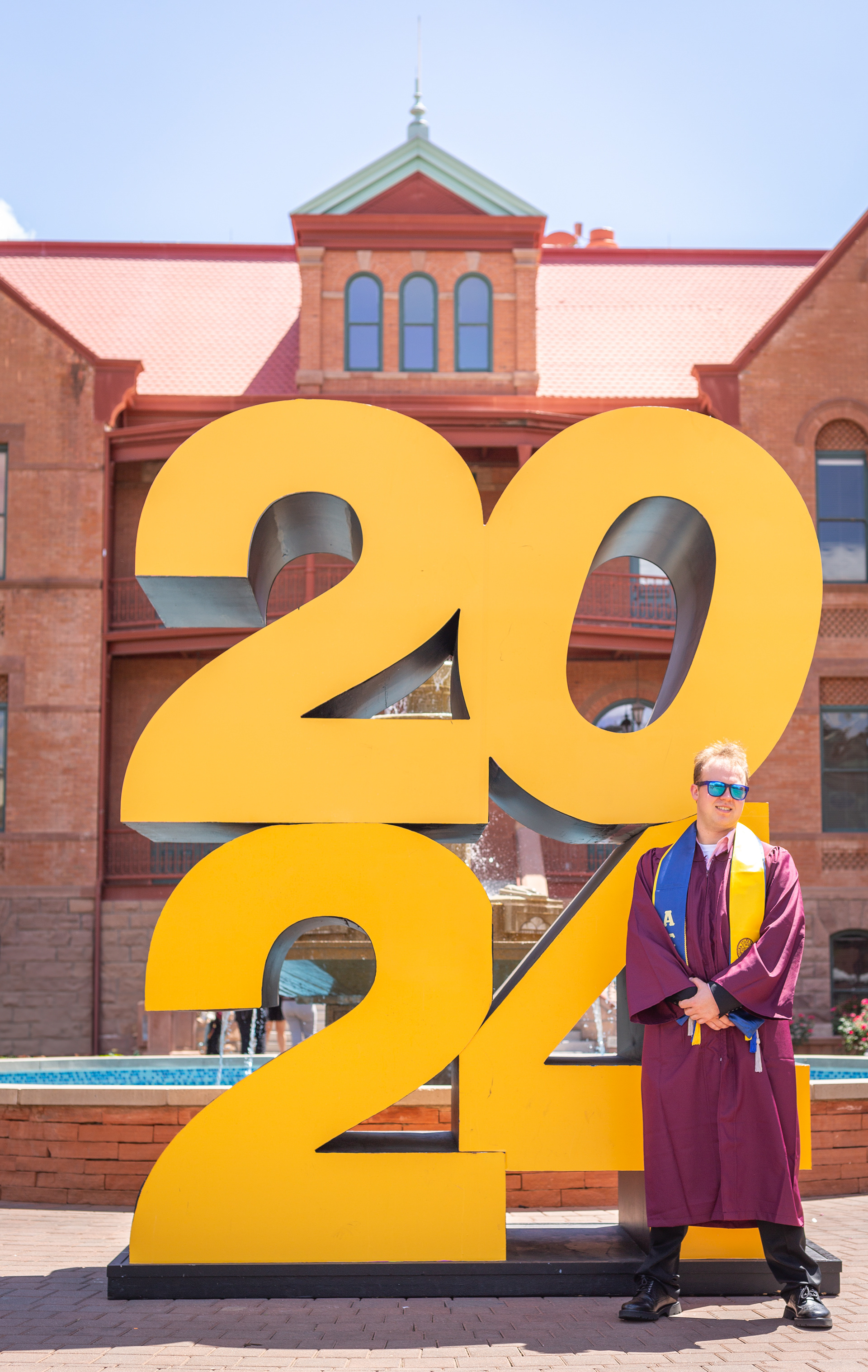 Tyler Baum, Arizona State University graduate, stands with the big 2024 sign outside of Old Main in Tempe, Arizona.