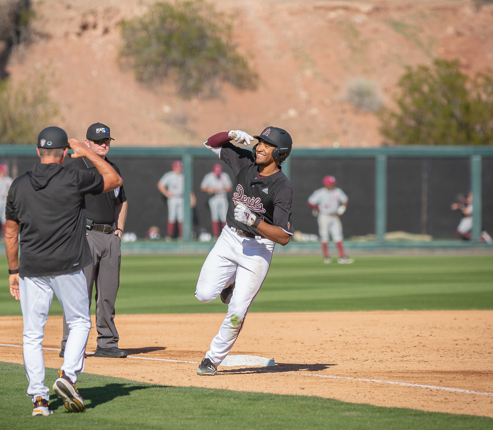 Isaiah Jackon, Arizona State University outfielder, salutes to the third base coach while rounding the bases after hitting a home run during a game at Phoenix Municipal Stadium on Saturday, February 17, 2024 in Phoenix, Arizona. 
