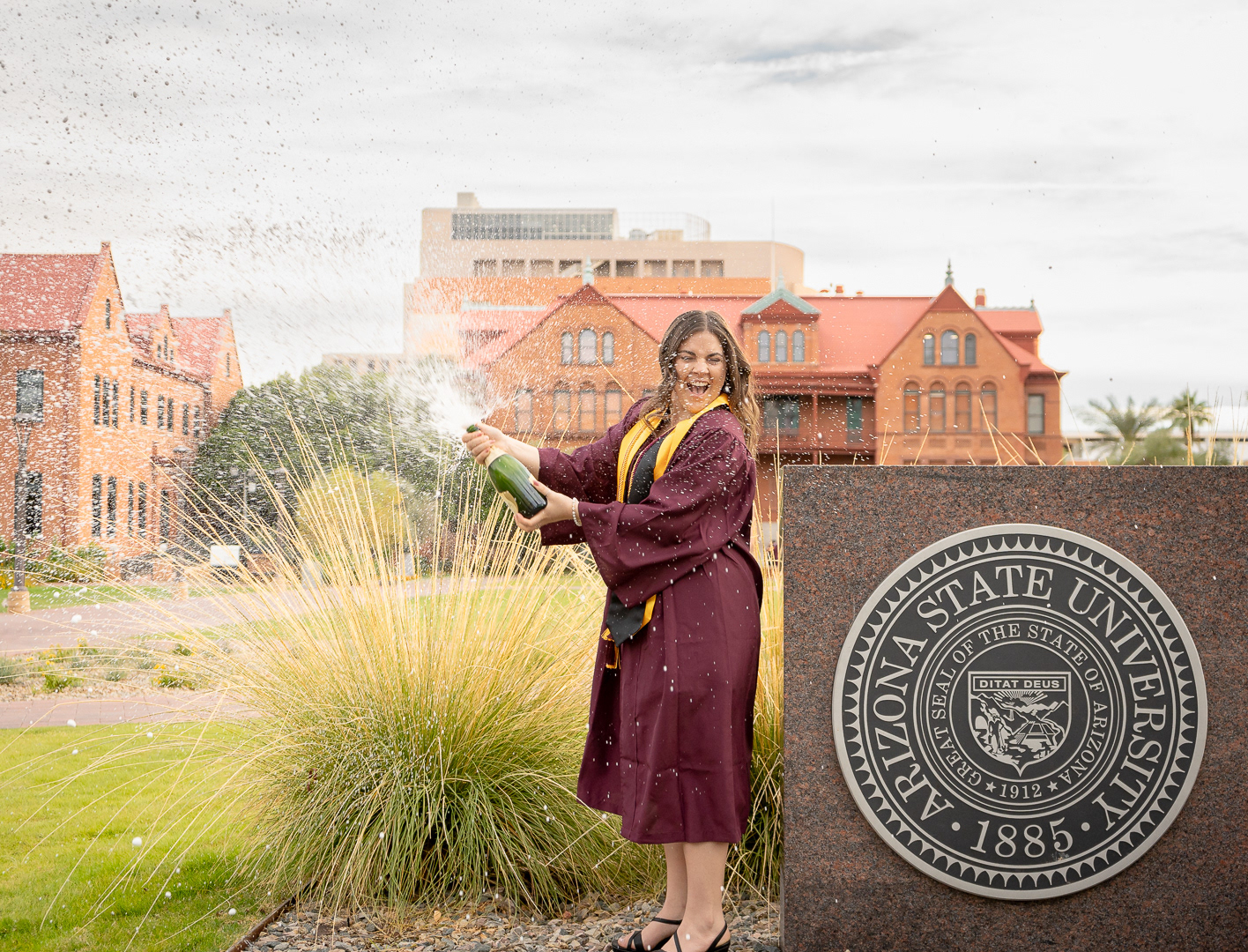 Kaitlyn Wolfe, Arizona State University graduate, pops a bottle of champagne celebrating her journey to graduation in Tempe, Arizona. 