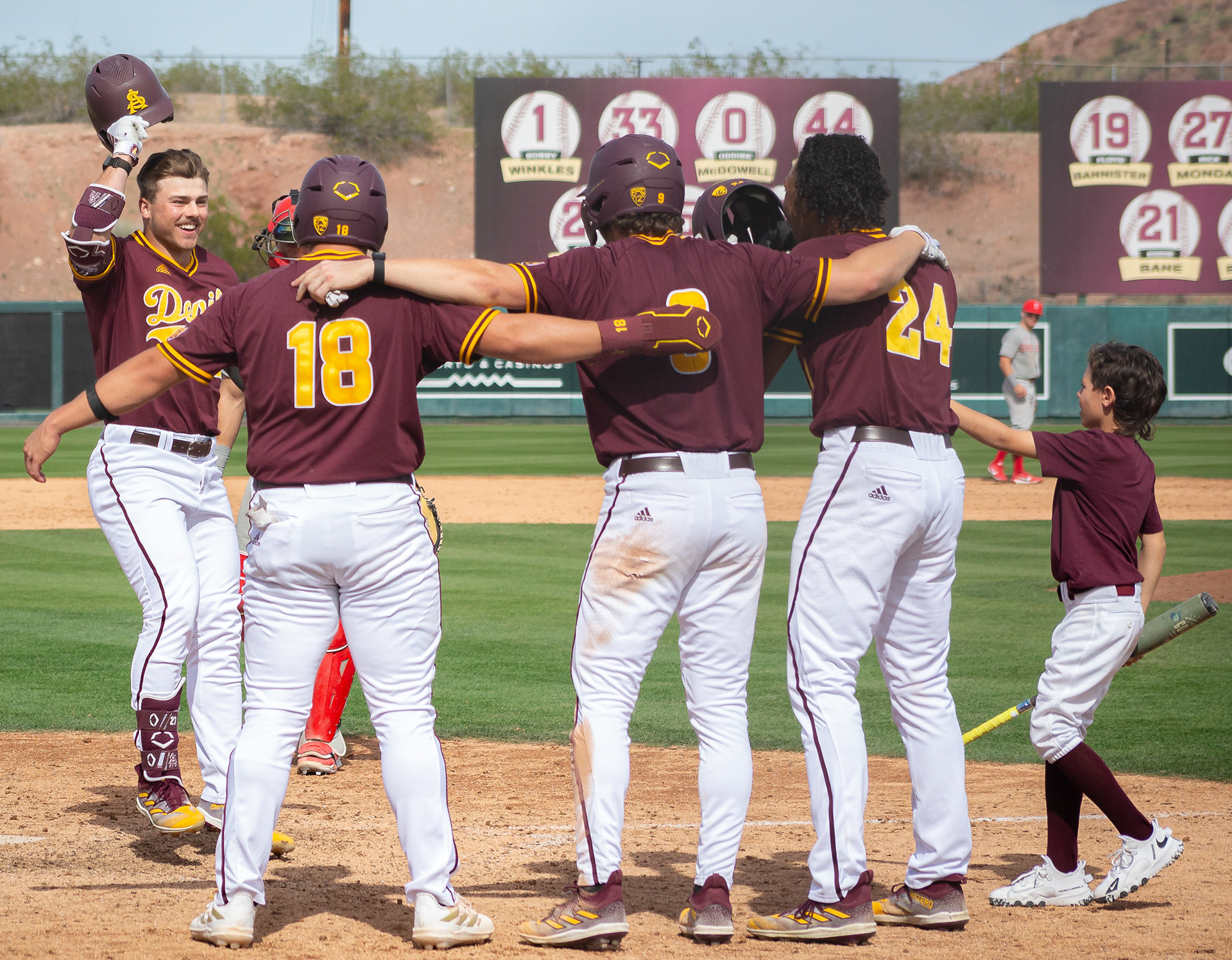 Brandon Compton, Arizona State University outfielder, celebrates a grand slam home run with teammates Jacob Tobias, Kevin Karstetter, and Isaiah Jackson during a game against Ohio State at Phoenix Municipal Stadium on Sunday, February 25, 2024 in Phoenix, Arizona. 