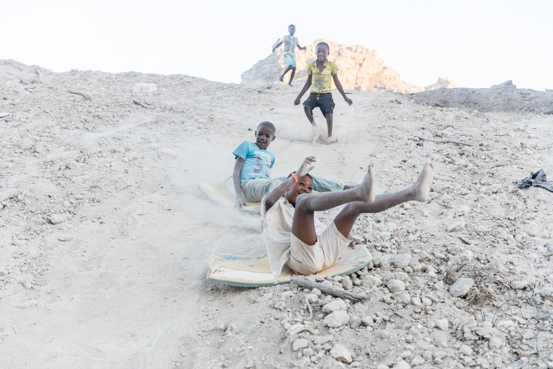 Cisco Ramosie and Emihle Morris slide down a construction site for formal housing chased by friends Mark Boois and Kyle Anthony.