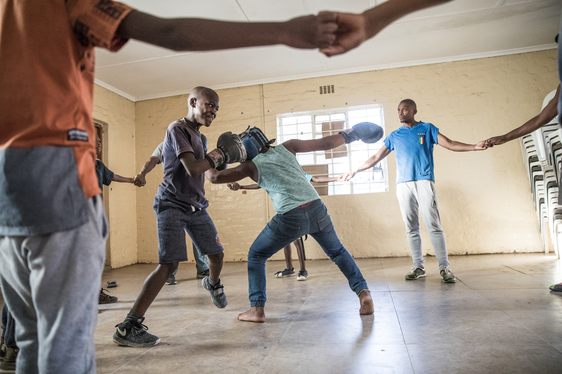 Fellow trainees form a makeshift ring by holding hands and encircling the opponents.
