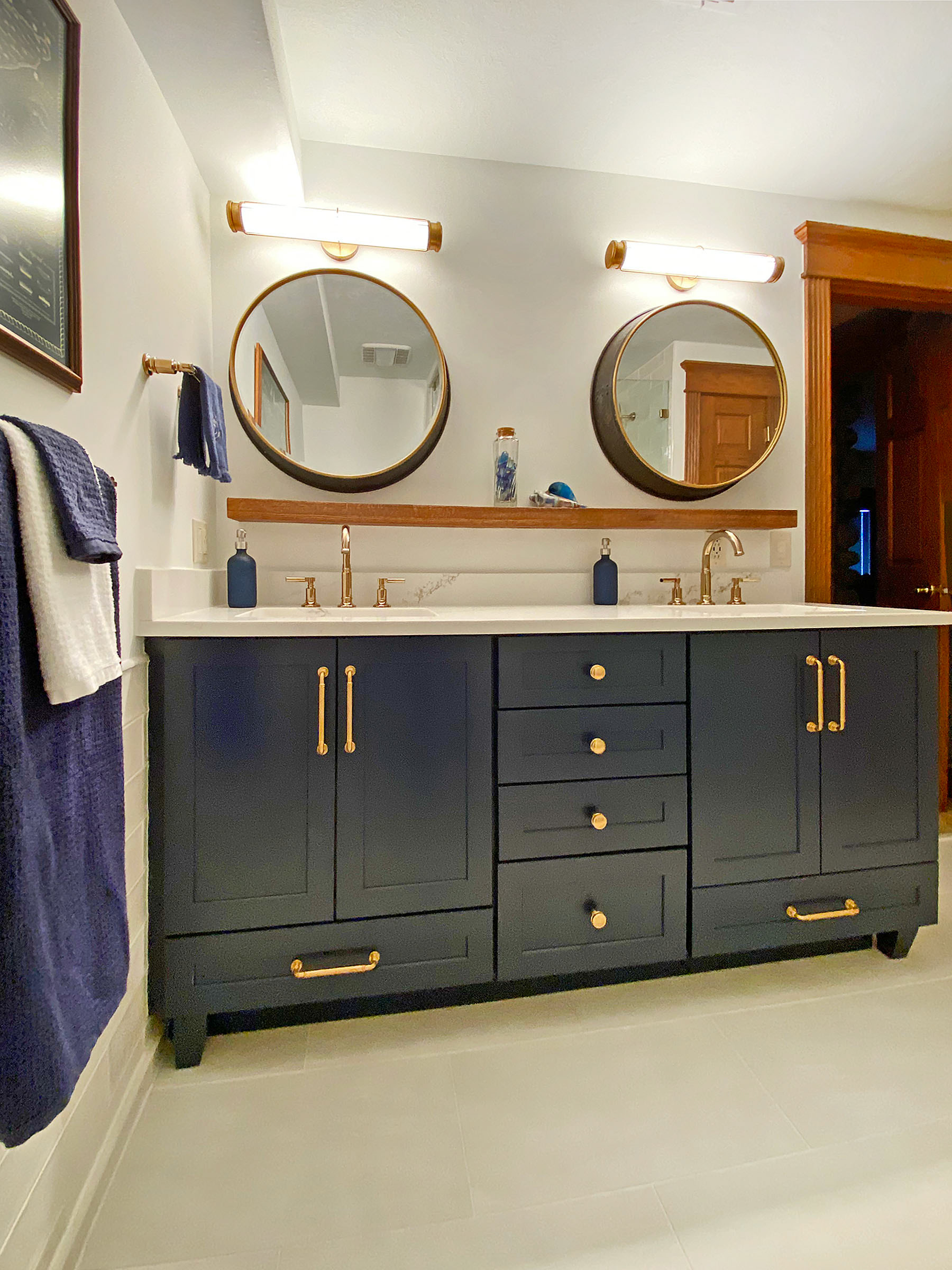 Nautical Theme Navy Blue Custom Cabinetry with Round Accent Mirrors and Bar Lighting