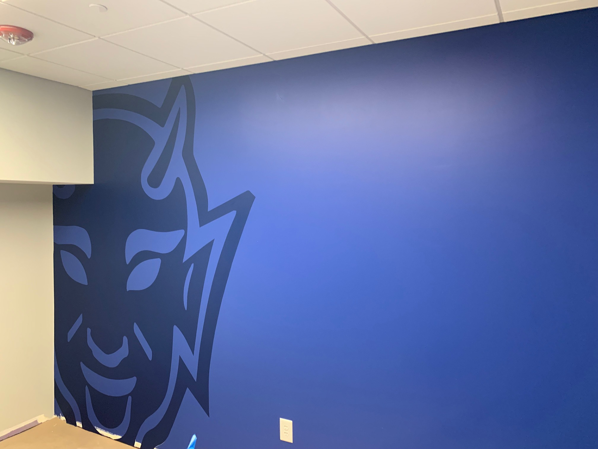 Duke Field Hockey • Coaches' Locker Room, step 1: Blue Devil wall graphic (large format digital print, hand cut, on blue painted wall, wide view)