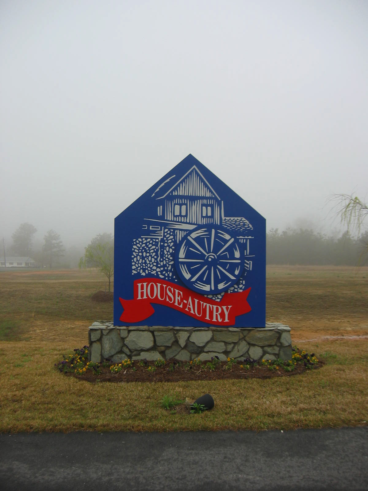 Fabricated aluminum monument with dimensional water wheel and reflective graphics on stone base