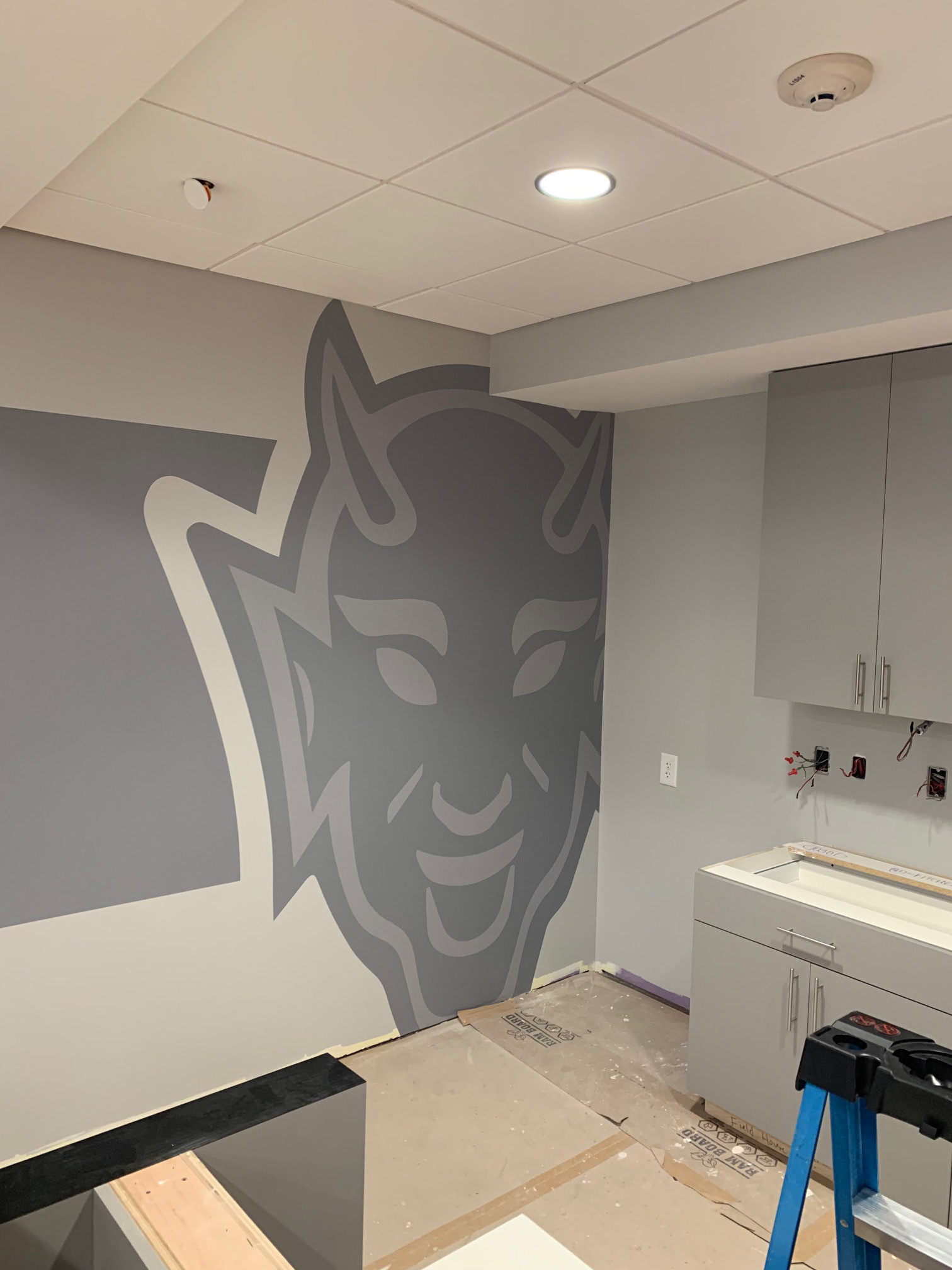 Duke Field Hockey • Team Room/Kitchen, step 2: Blue Devil wall graphic (large format digital print, hand cut)
