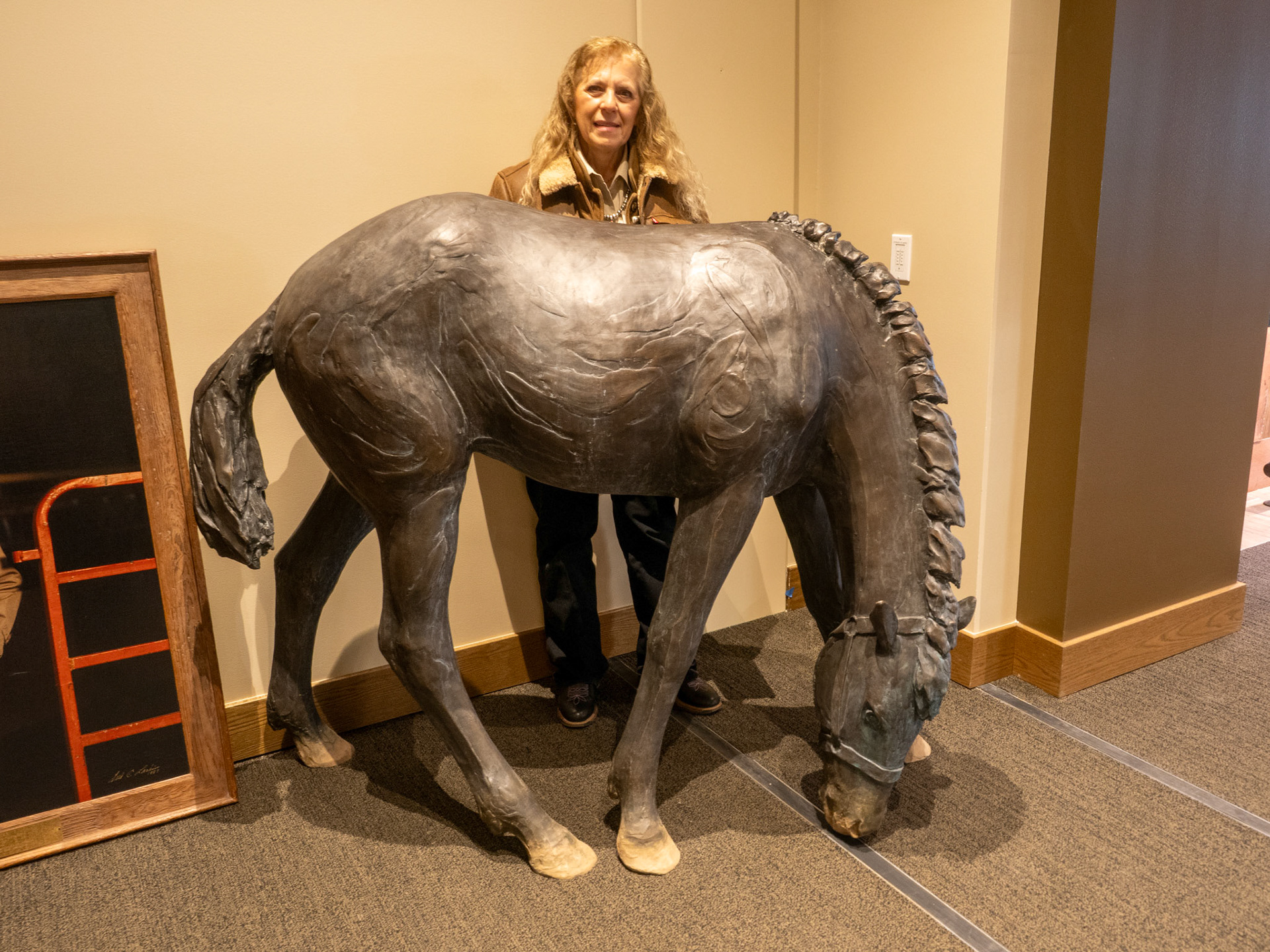 Kym Morrissey behind large bronze horse