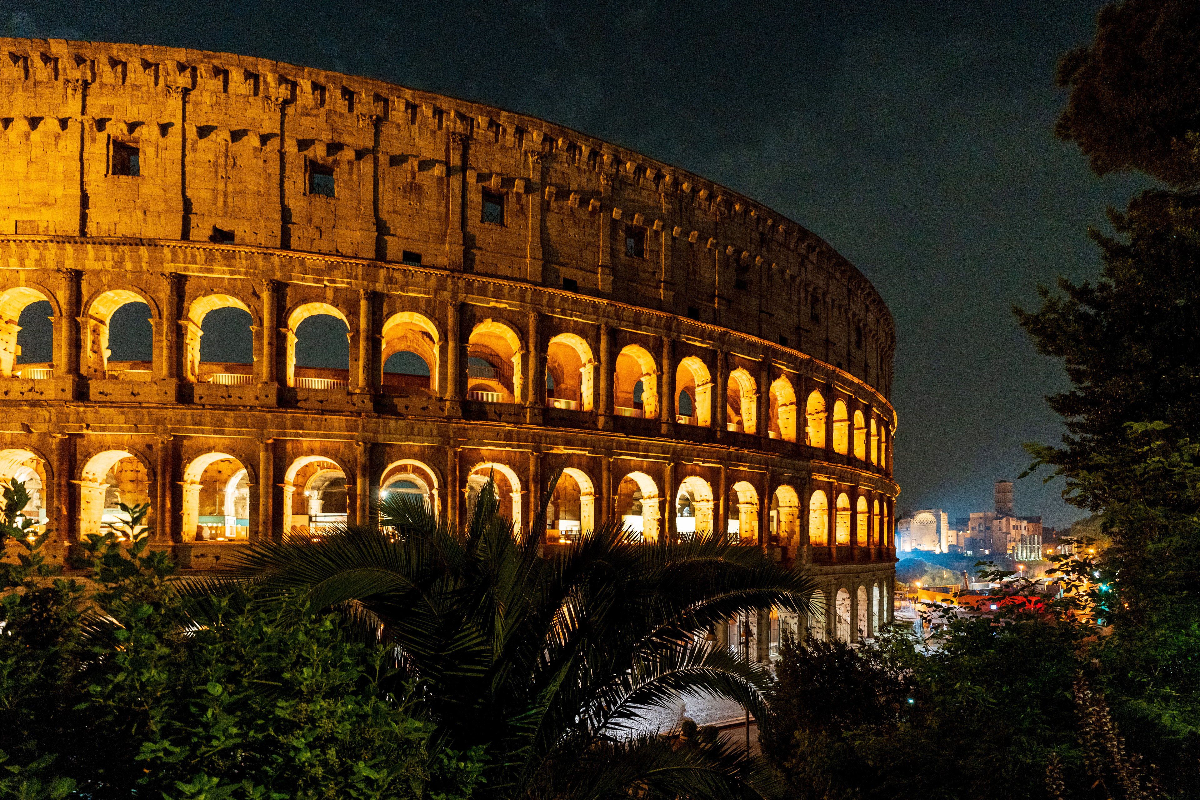 Le colisée de nuit, au loin le forum romain