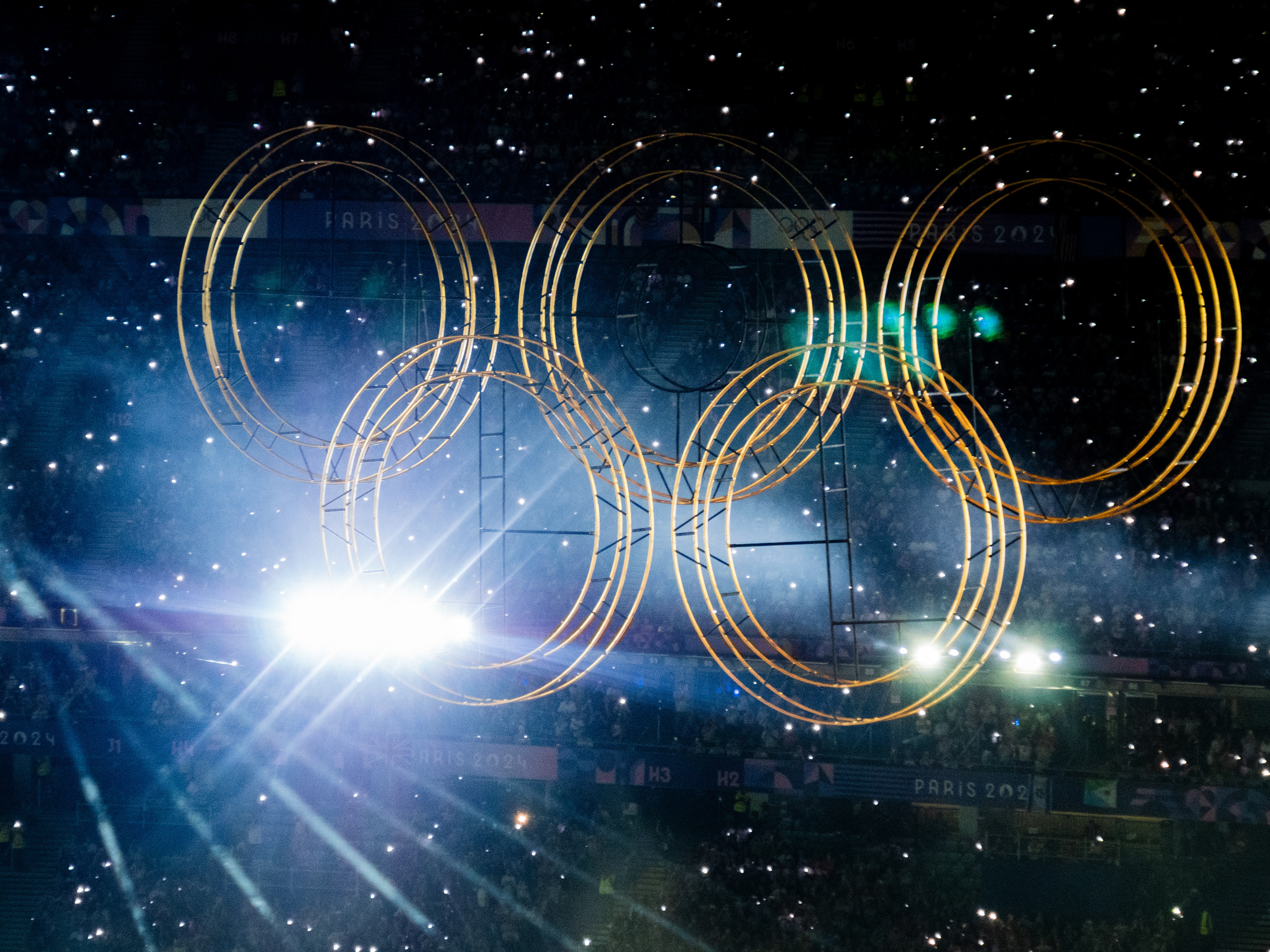 Elevation des anneaux olympiques, tribune illuminée d'étoiles
