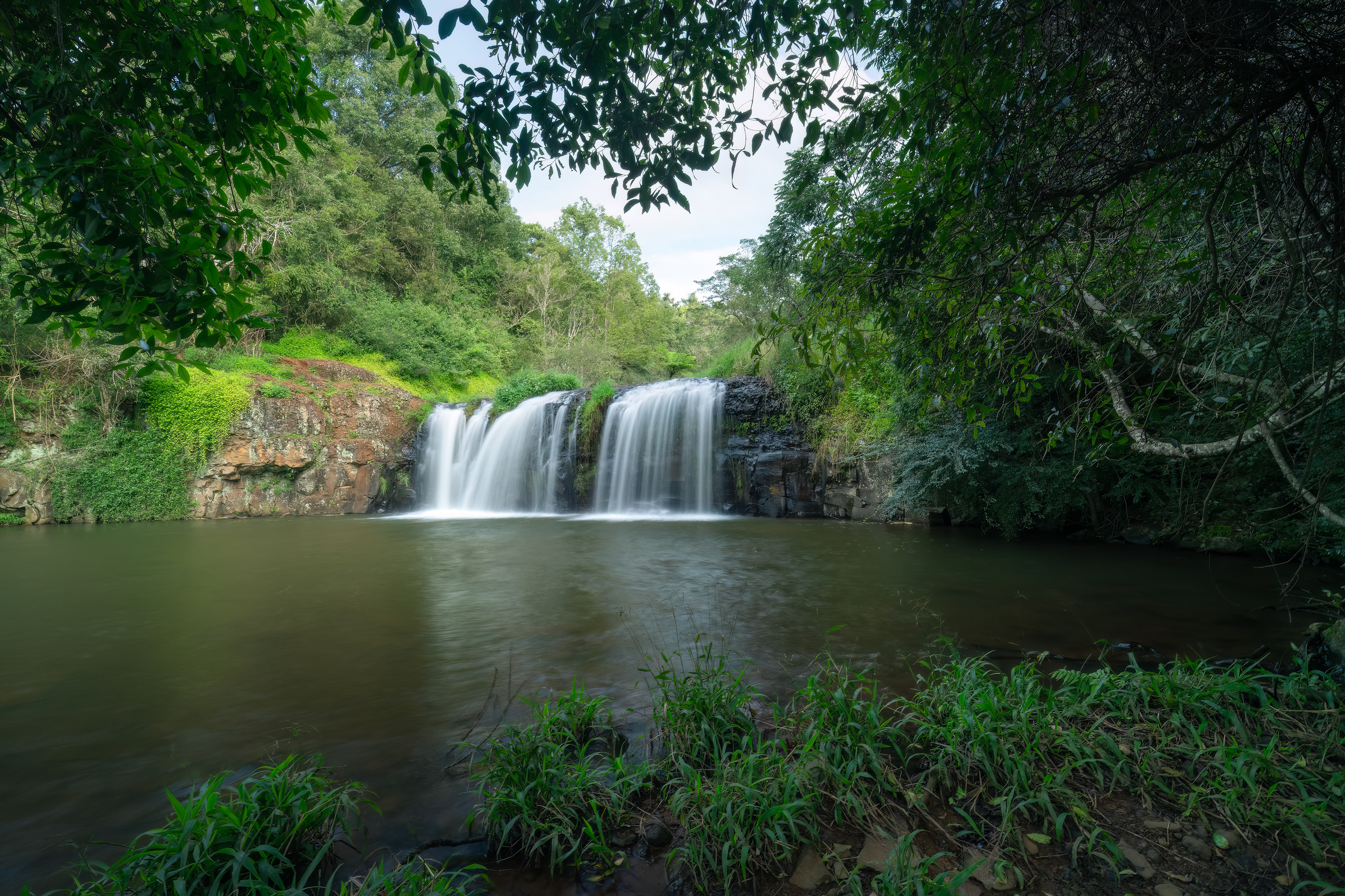 Tosha Falls waterfall flowing into a natural rock pool near Alstonville