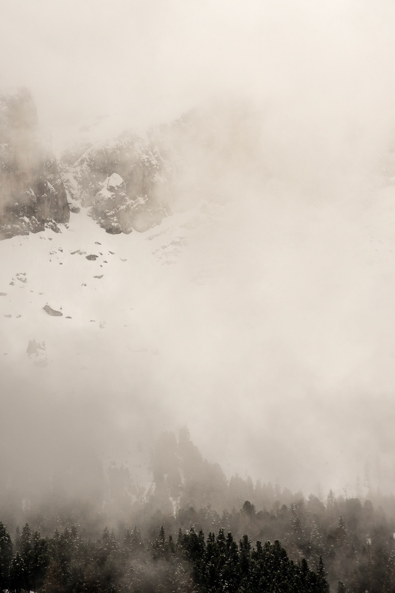 Shy mountains hidden behind banks of fog and low clouds.