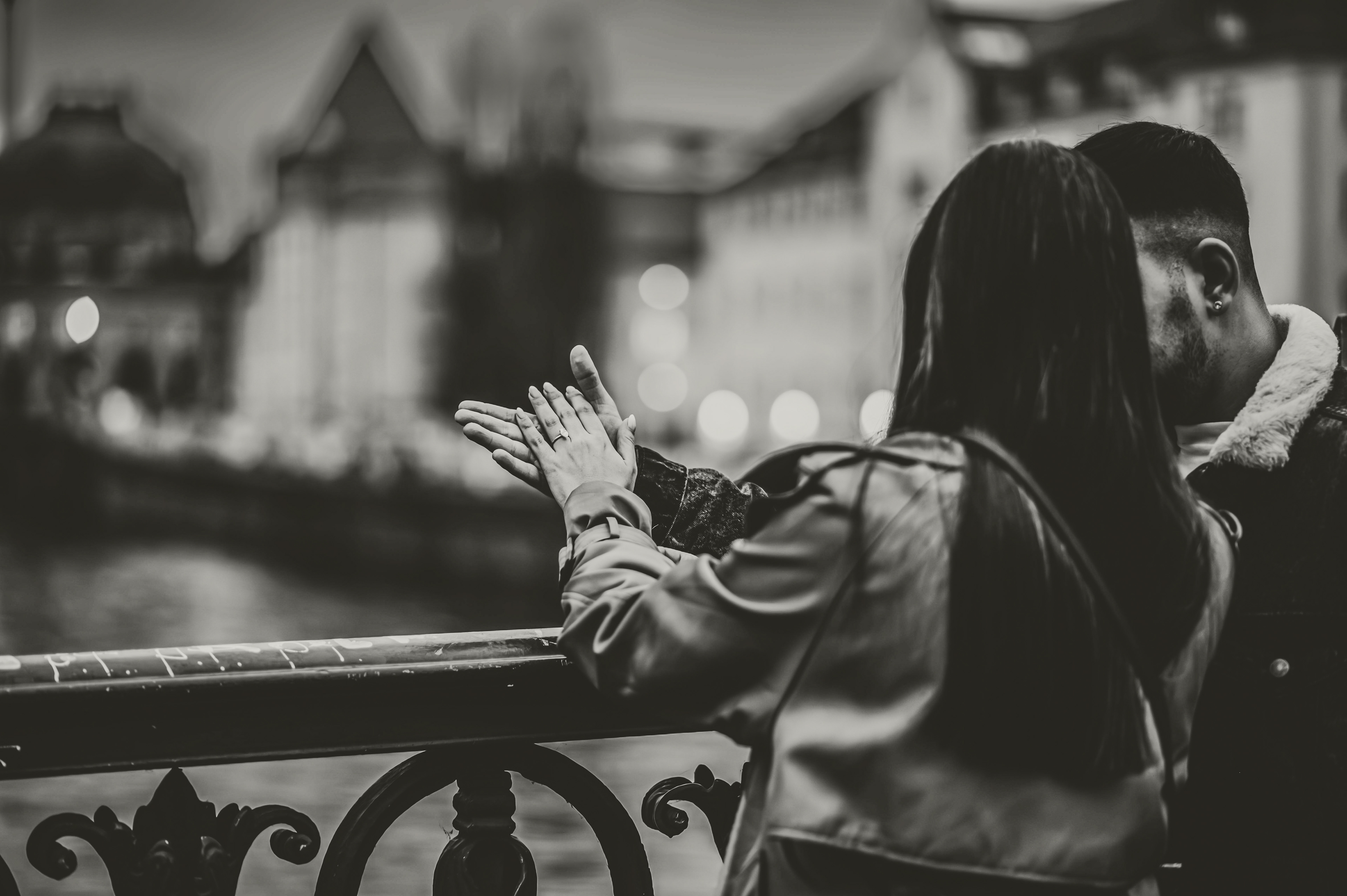 A couple standing with their back and looking at their engagement ring