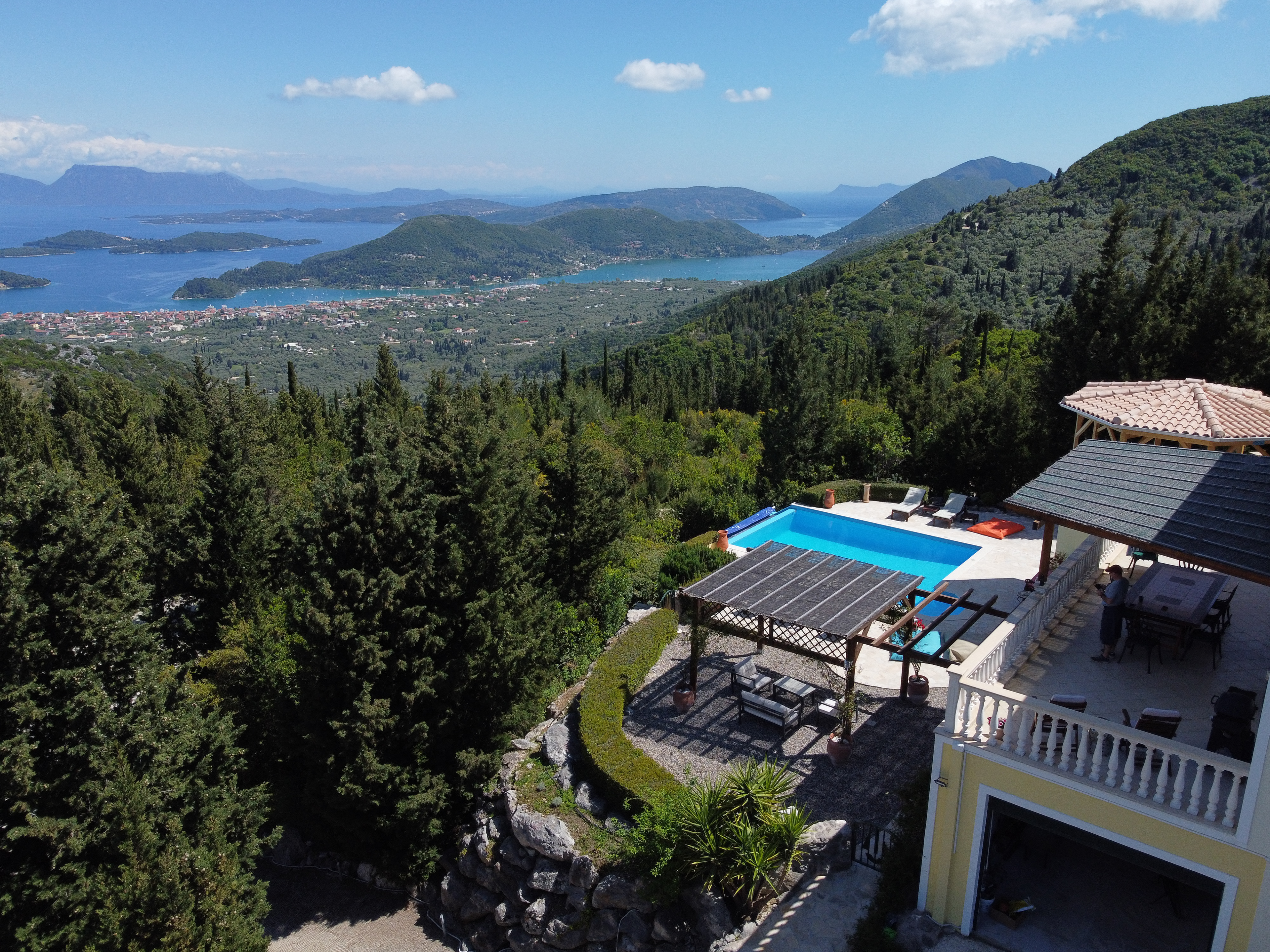 Panoramic view from Villa Gabriella over cypress-covered hills to Nidri and Vliho Bay, with the famous island of Skorpios shimmering in the Ionian Sea