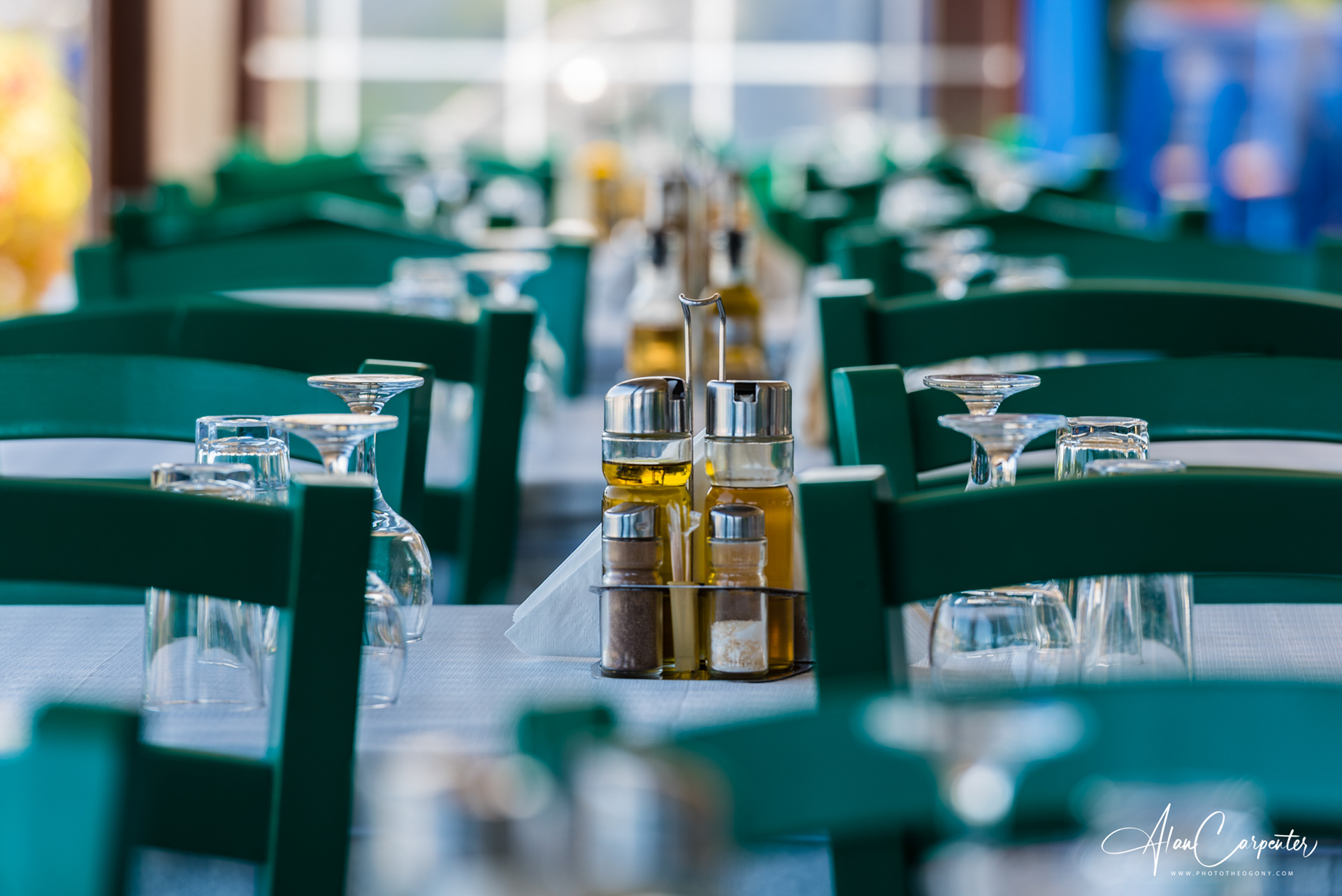Taverna life. Traditional green chairs, olive oil on every table, the clatter of plates and happy chatter — this is Greek family dining at its best