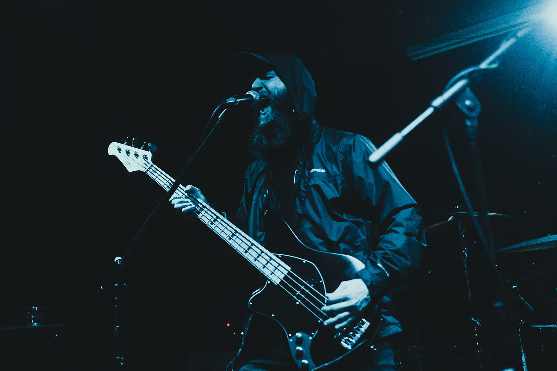 Joshua Tomlinson playing bass guitar and yelling into a microphone