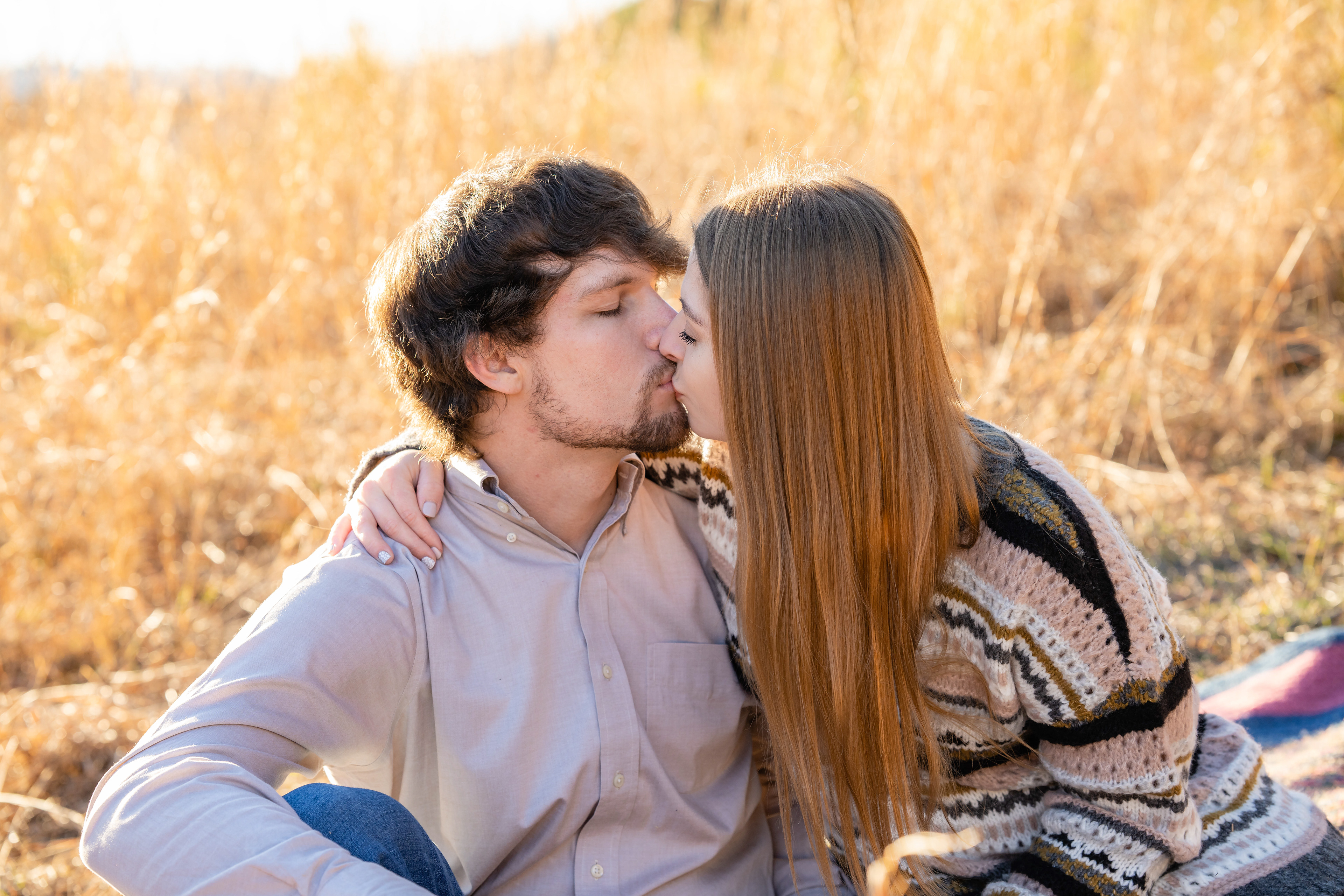 Couple kisses in hay field
