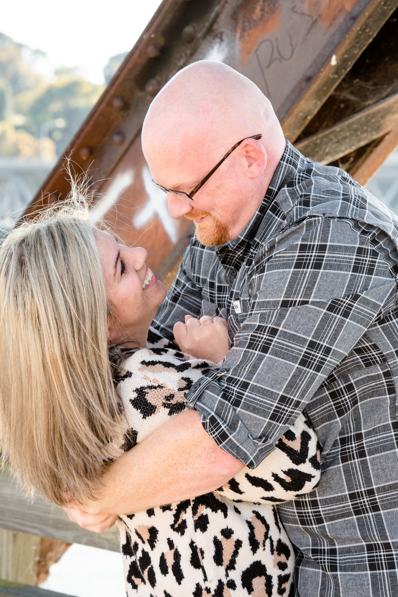 Husband bear hugs his wife
