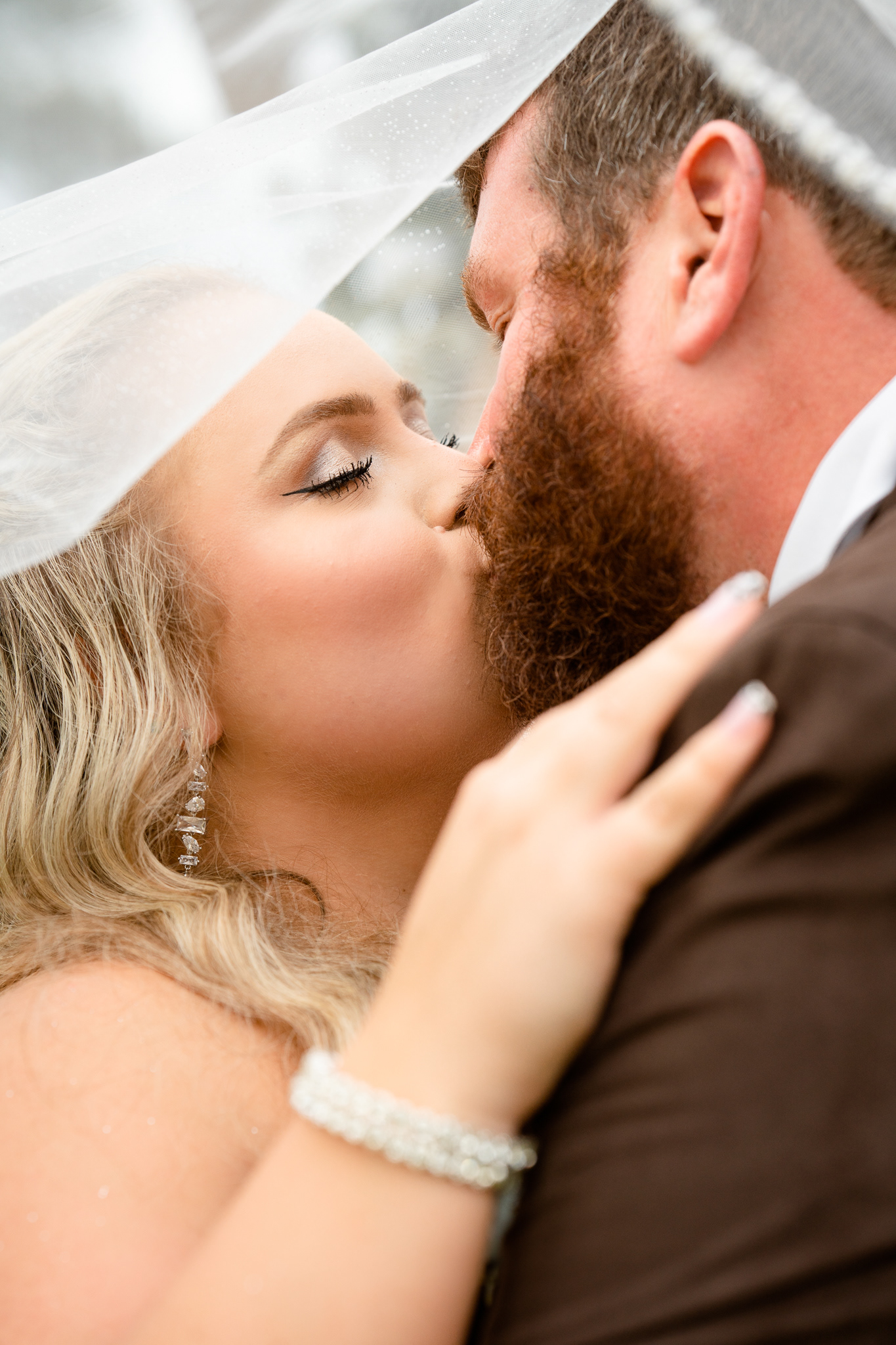 Bride and groom kiss under the bride's veil
