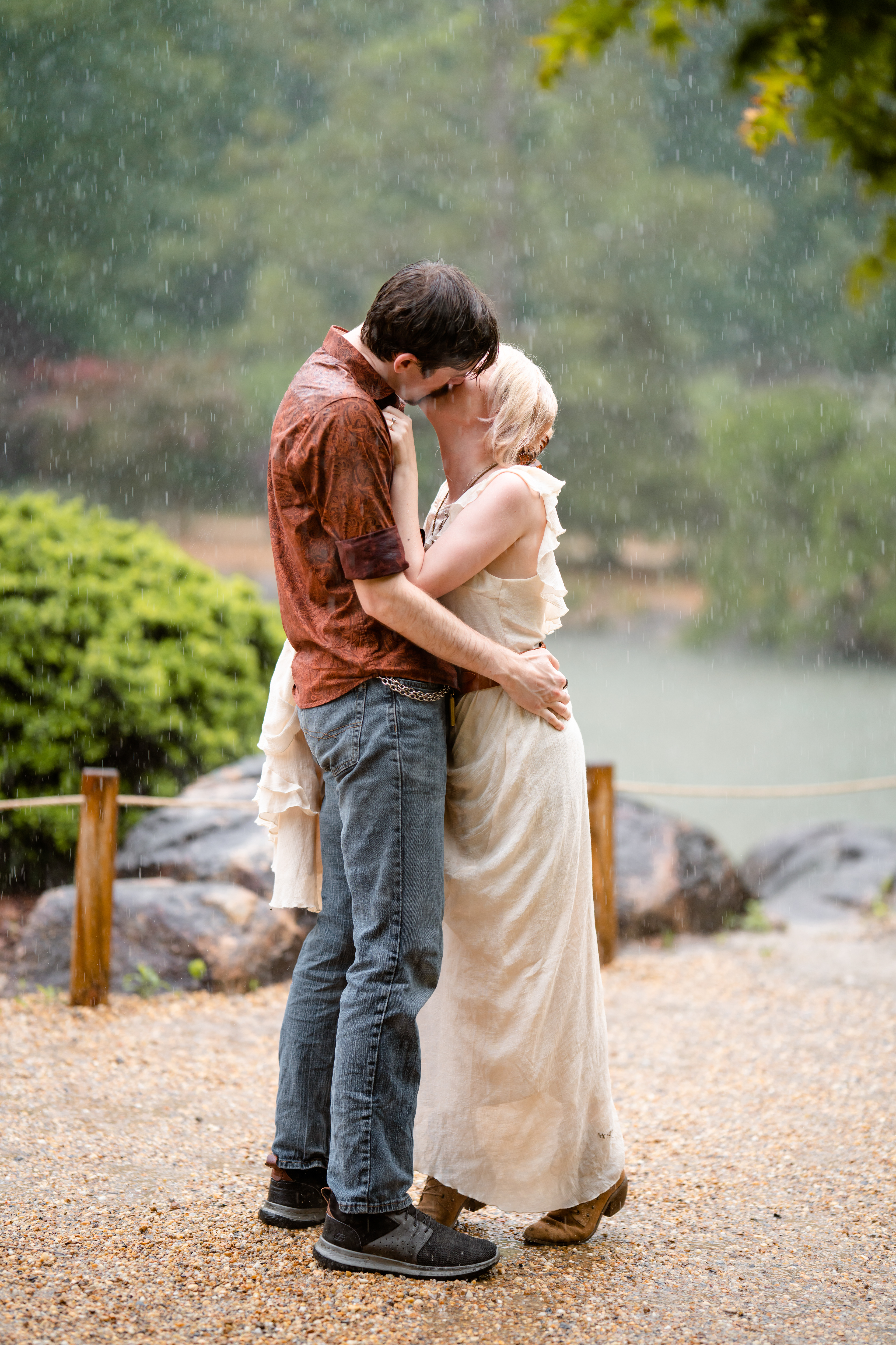 Engaged couple kiss in the rain