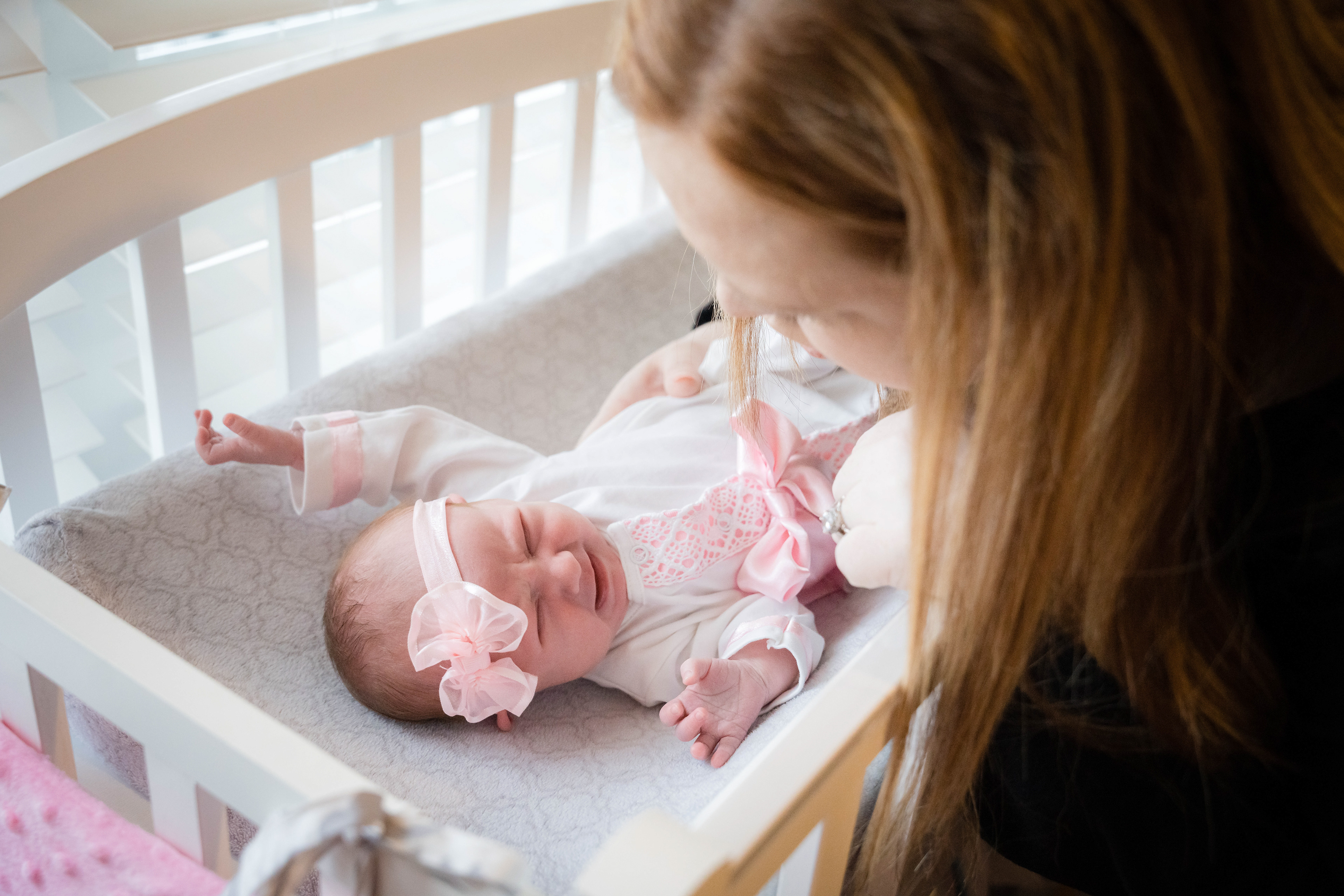Newborn cries as Mom changes her clothes