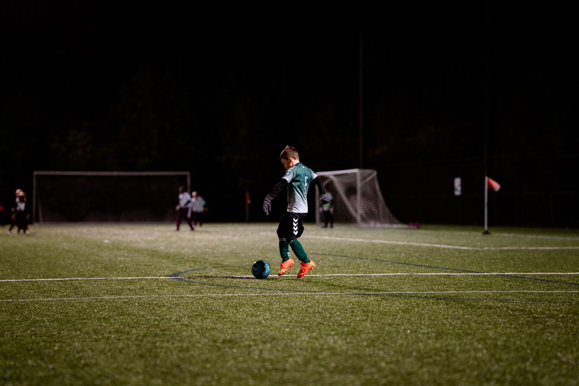 Little boy prepares to kick soccer ball to teammate