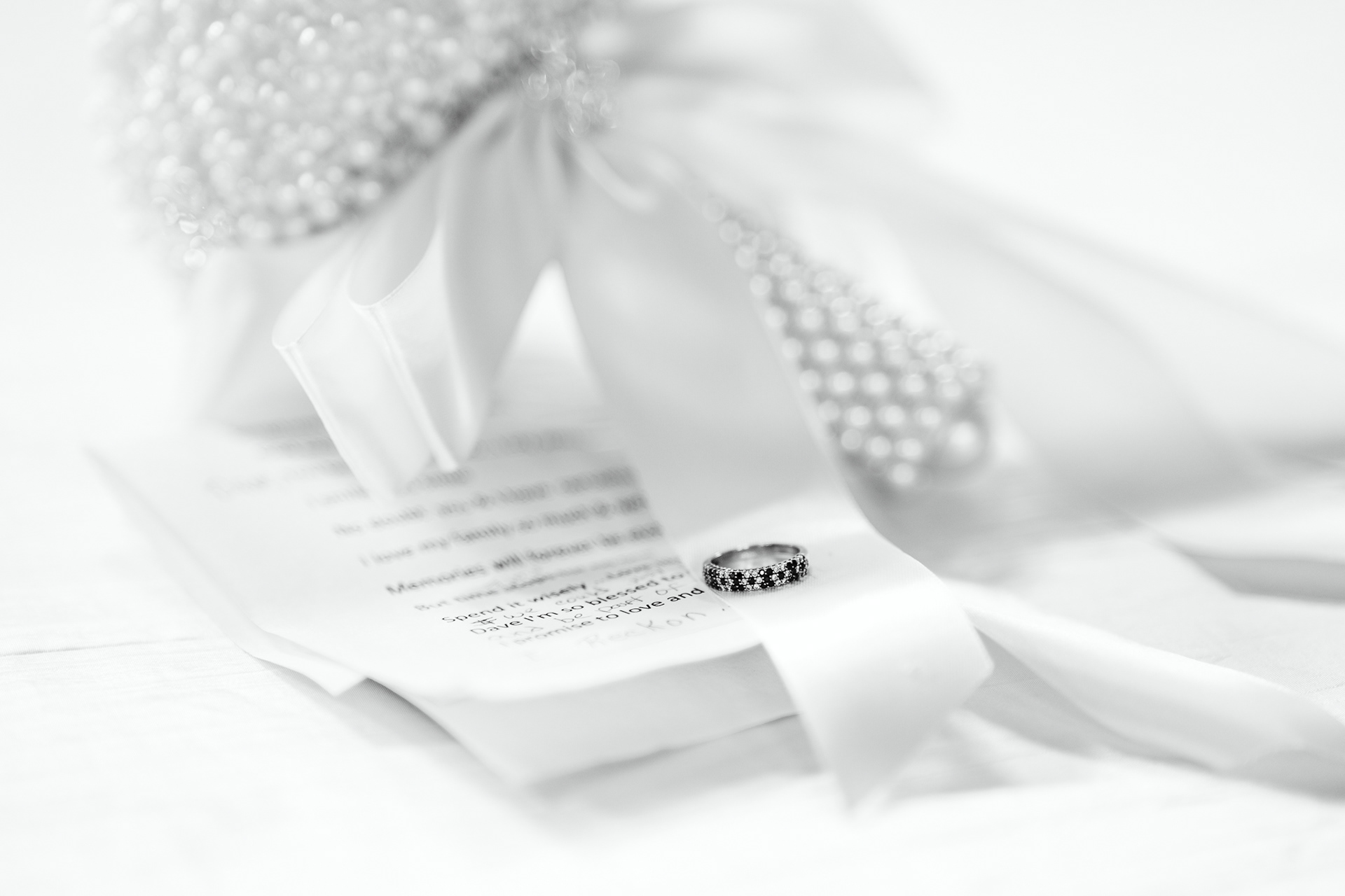 Wedding ring on bouquet and vows