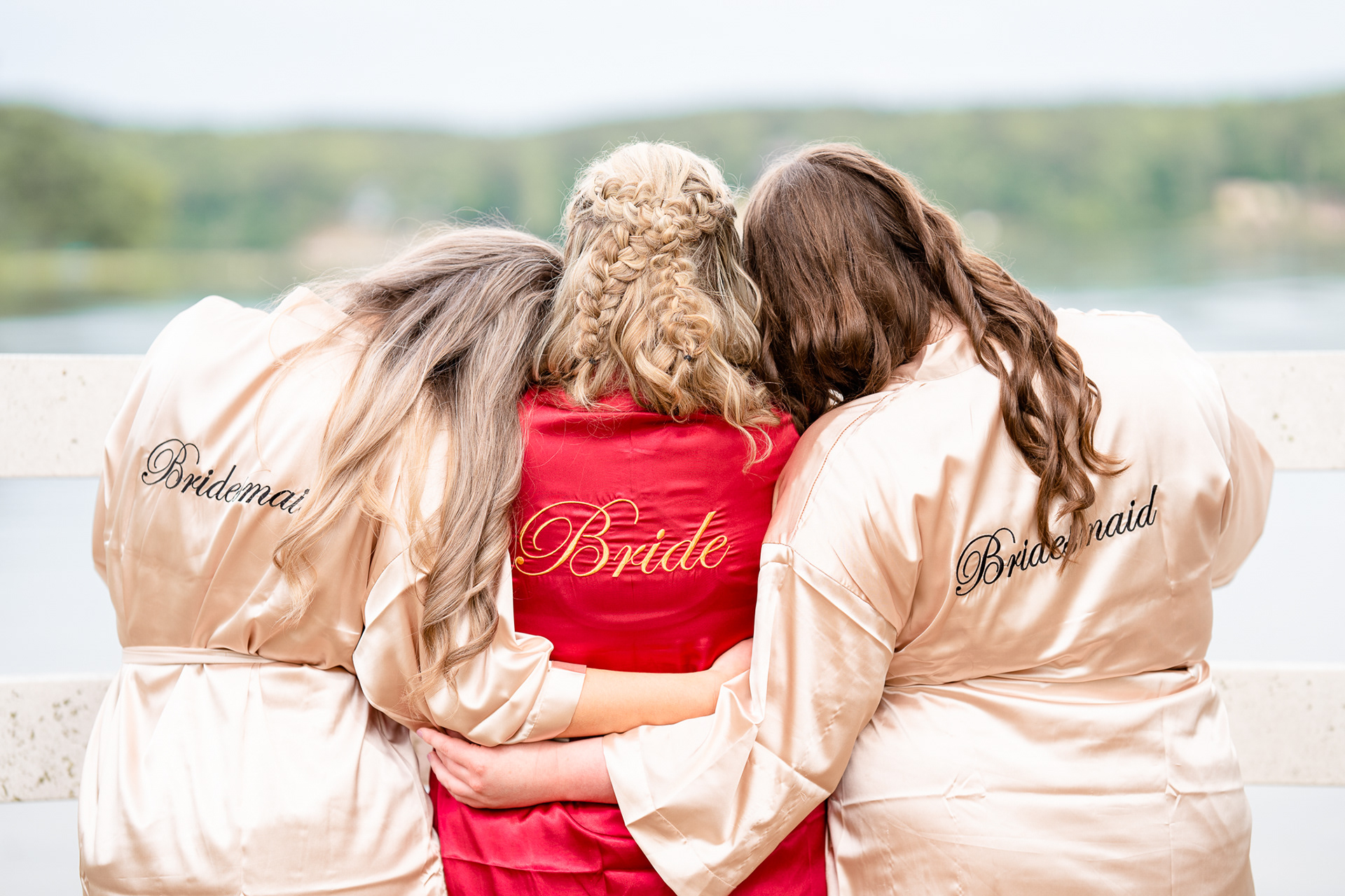 Bridesmaids hug the bride