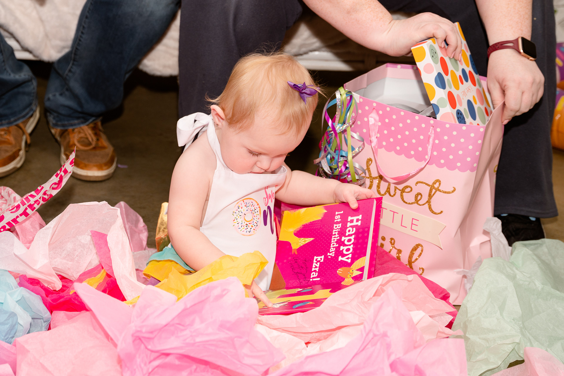 Birthday girl opens her first birthday gifts