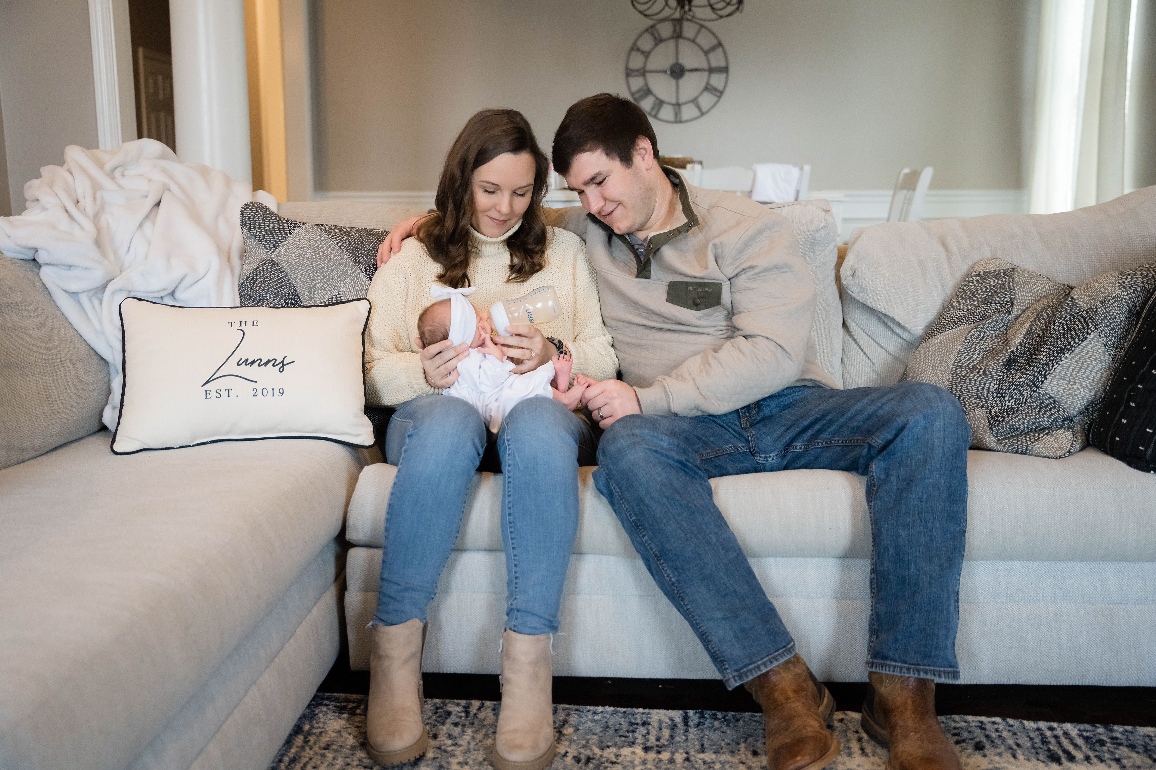 New mom and dad watch daughter feed in the comfort of their home