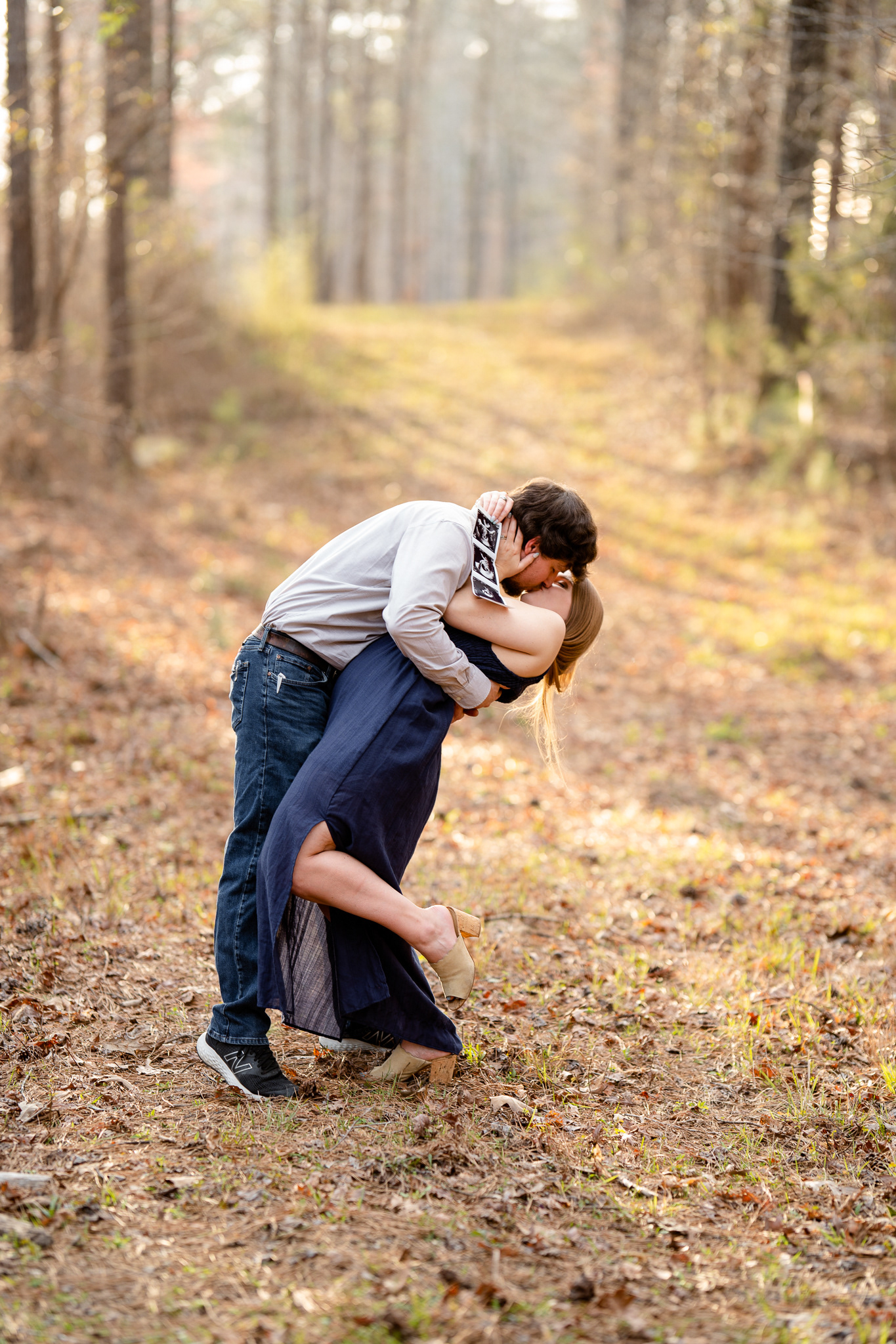 Couple kissing while holding sonogram