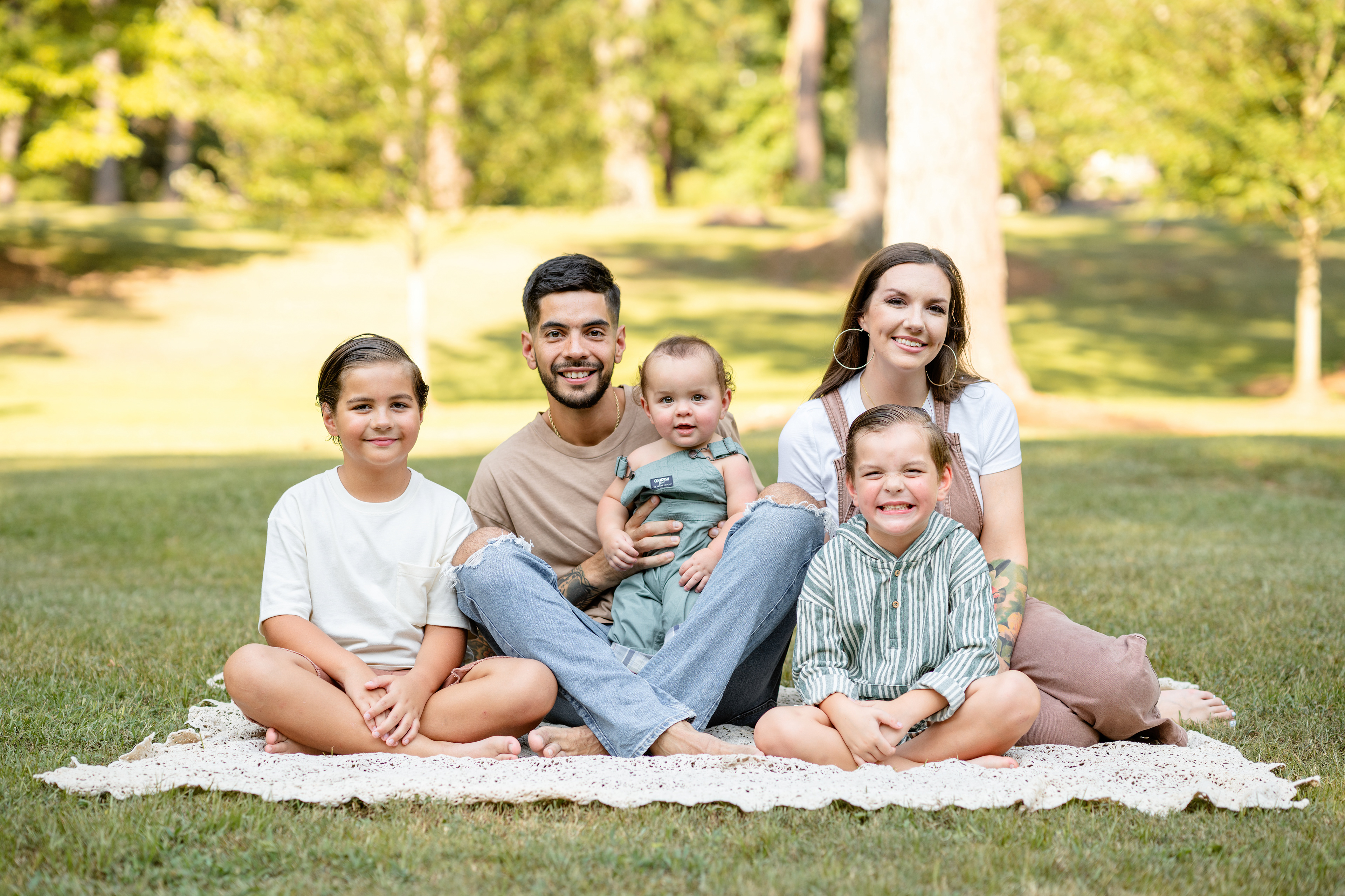 Family of 5 pose for a photo in a park