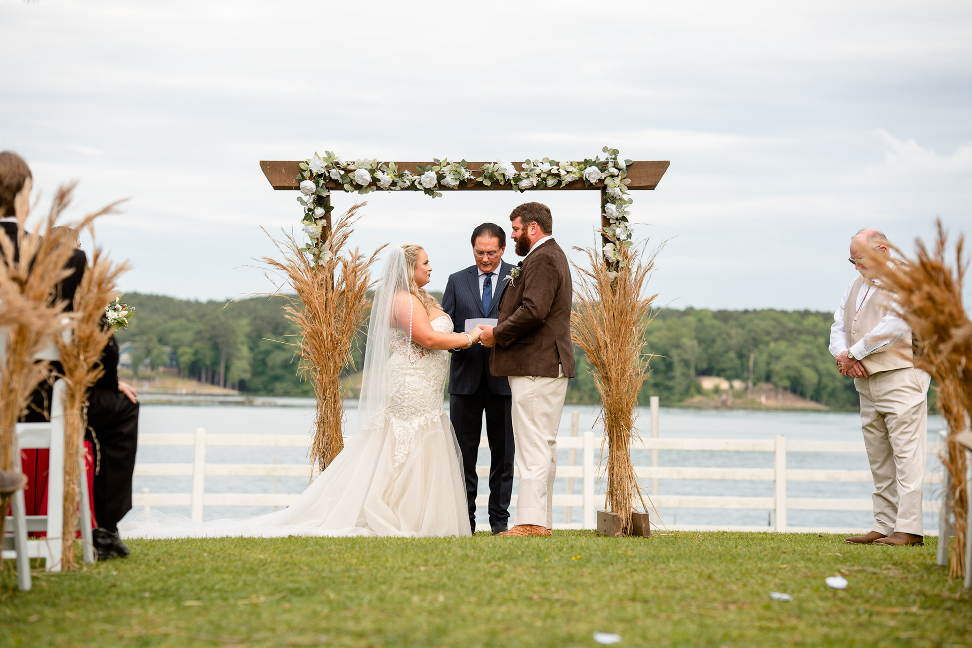 Bride and groom hold hands during their wedding ceremony