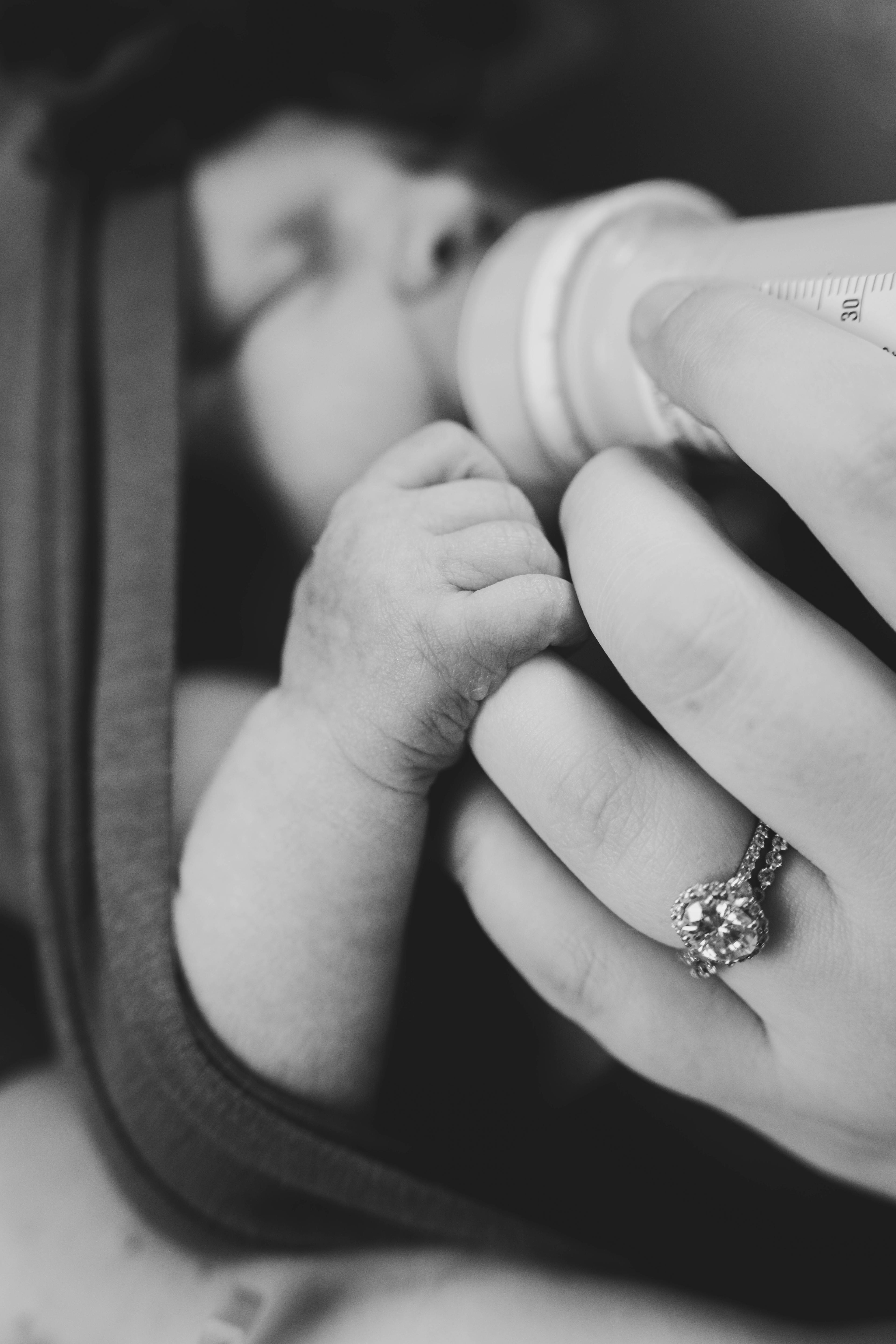 Baby hold her mommy's finger as she feeds