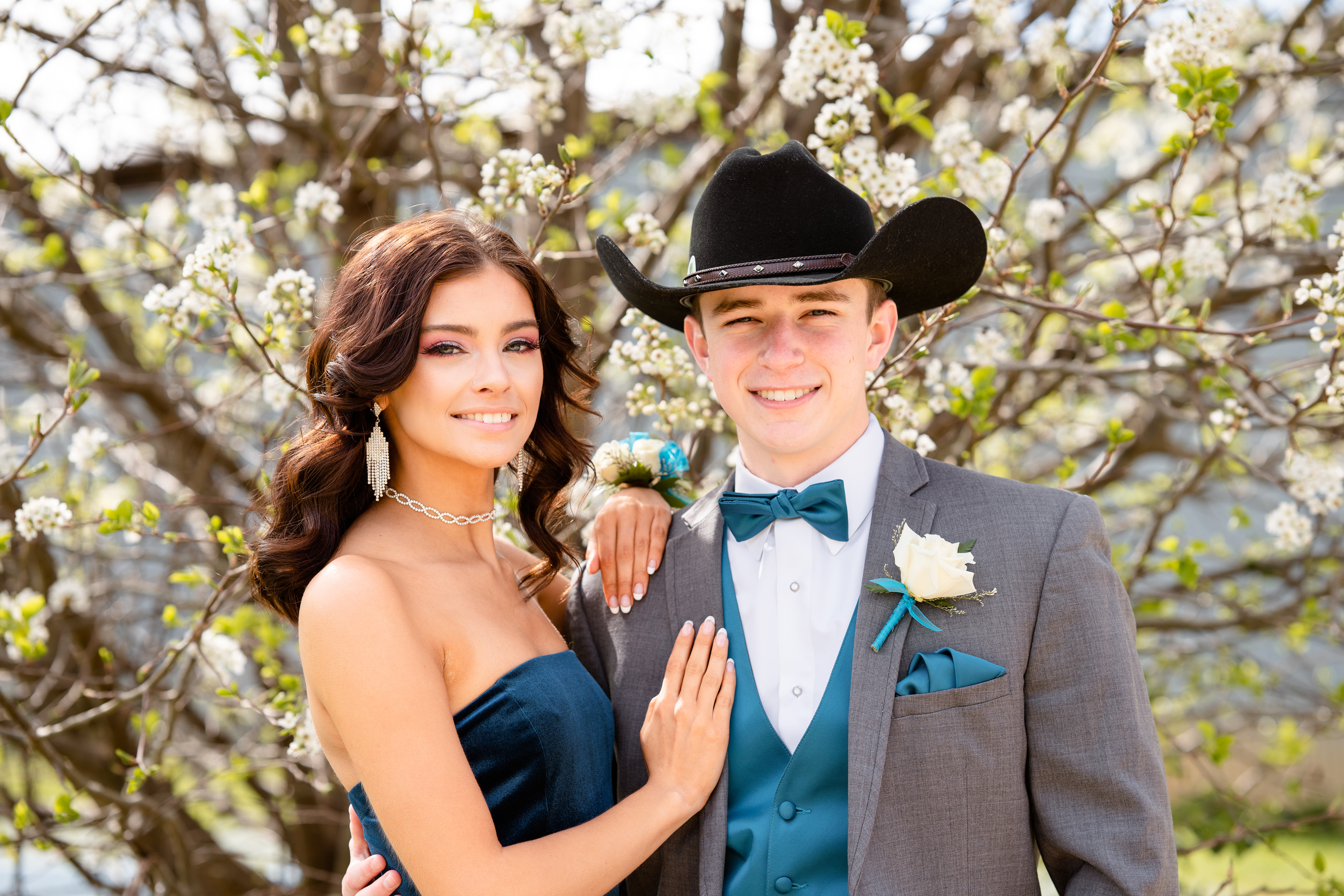 Prom dates standing in front of flowering tree
