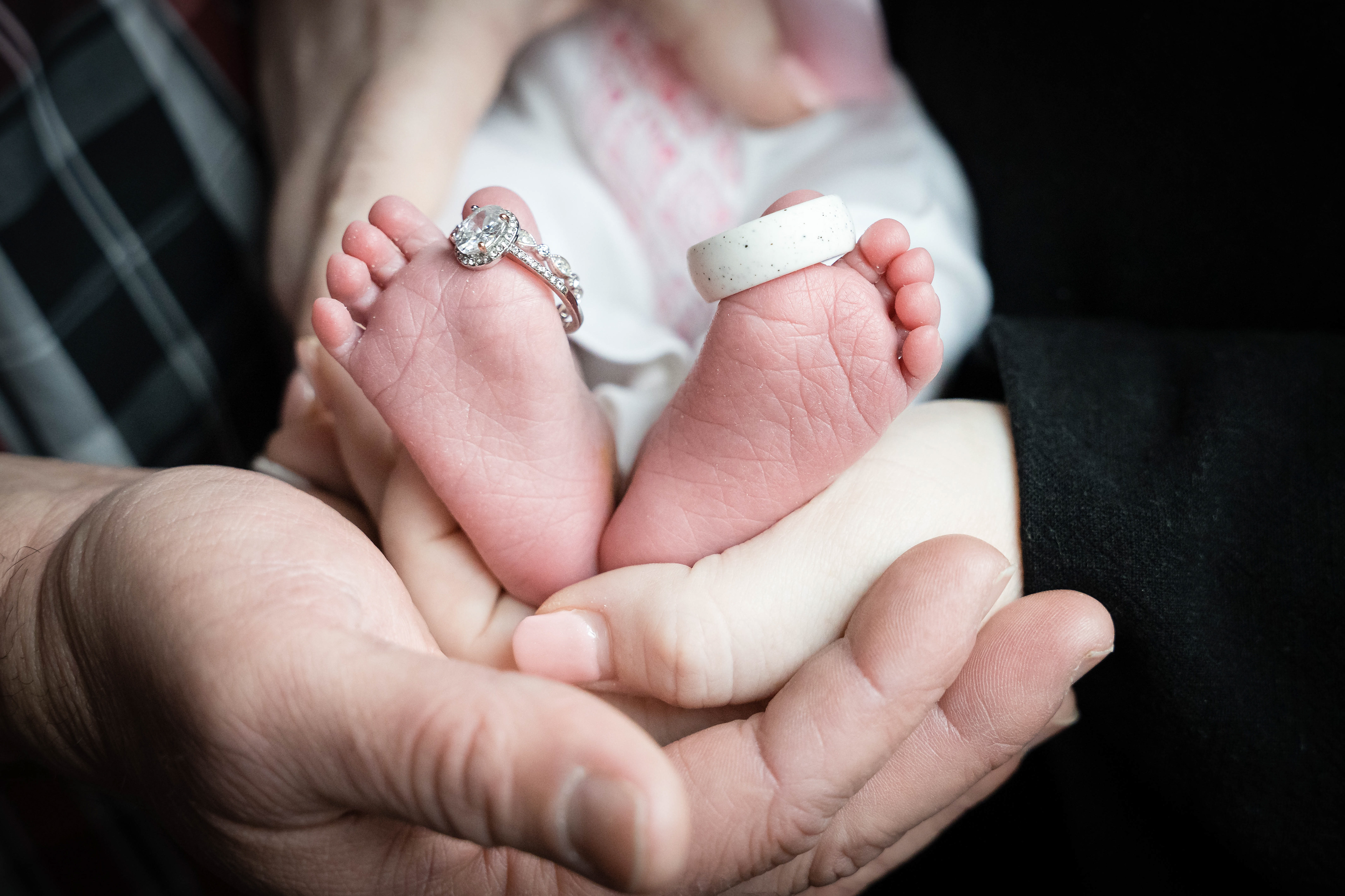 Newborn's toes show parents' wedding rings