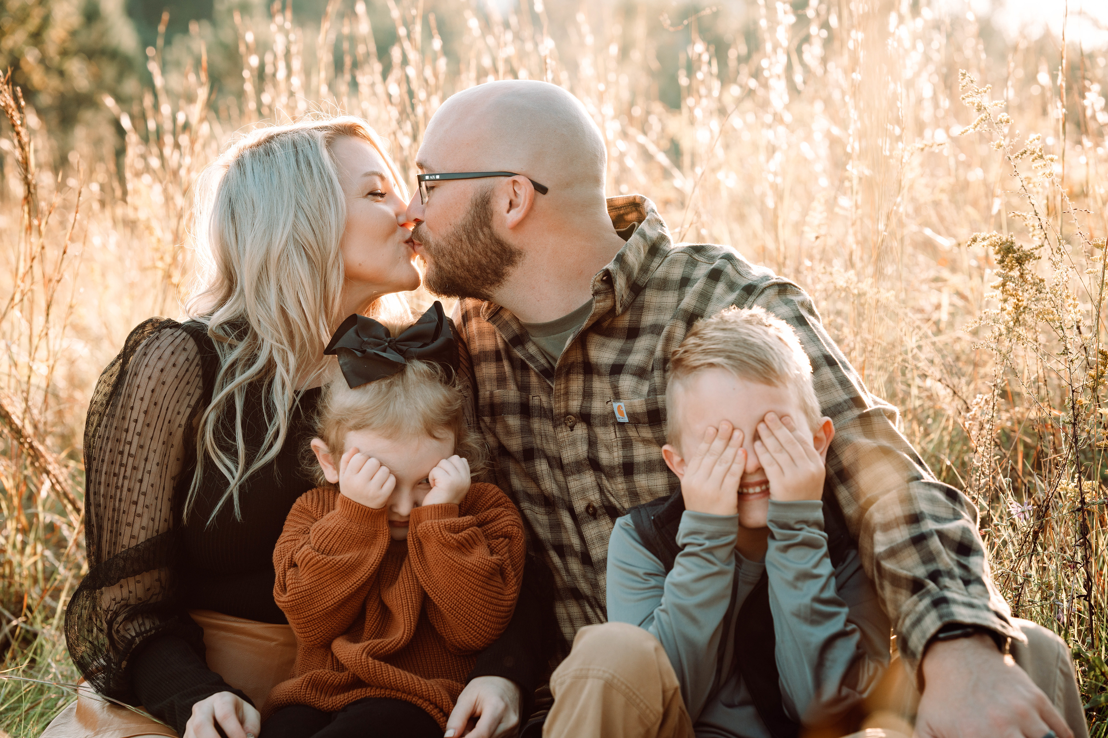 Kids cover their eyes as their parents kiss