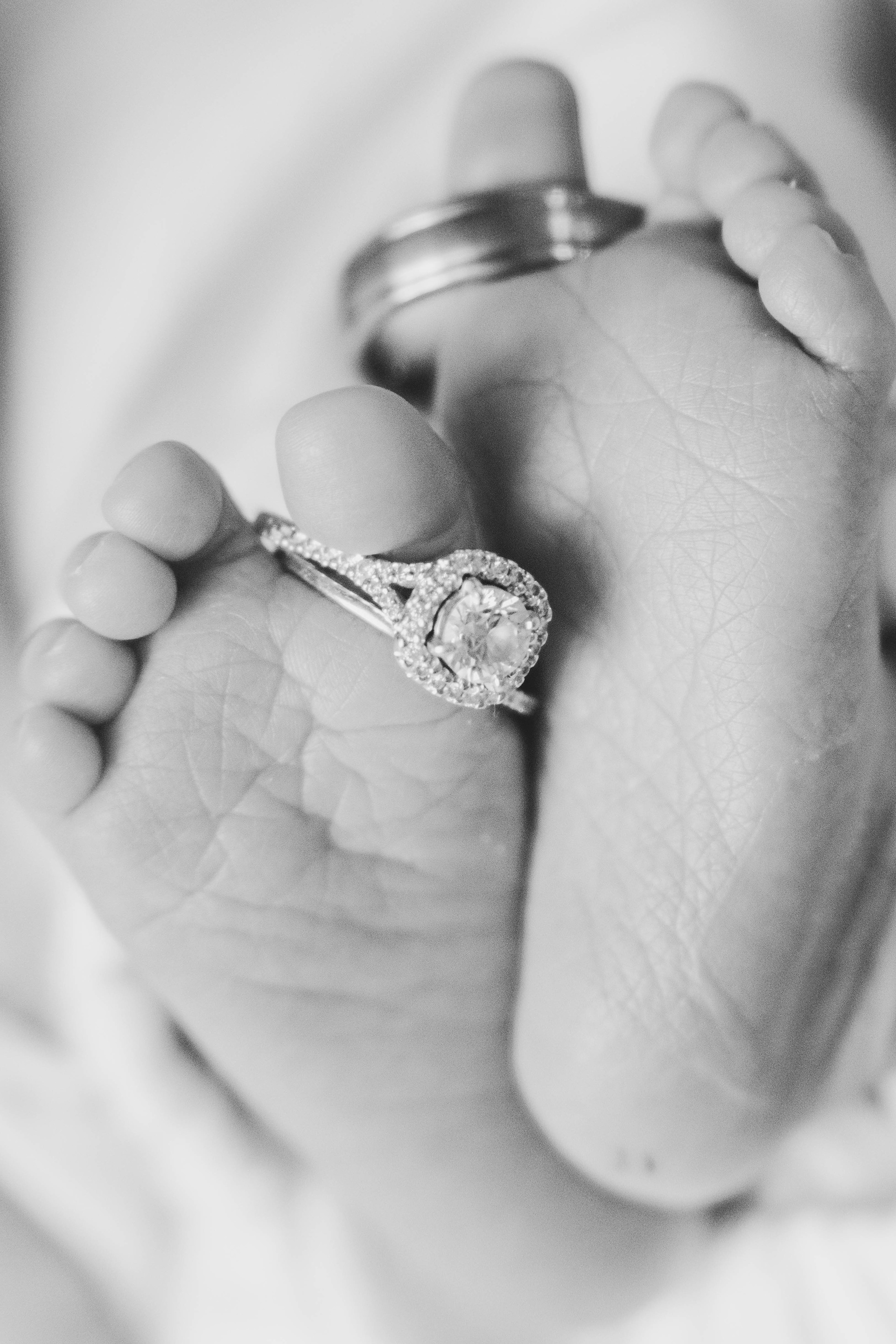 Newborn's toes hold mommy and daddy's wedding rings