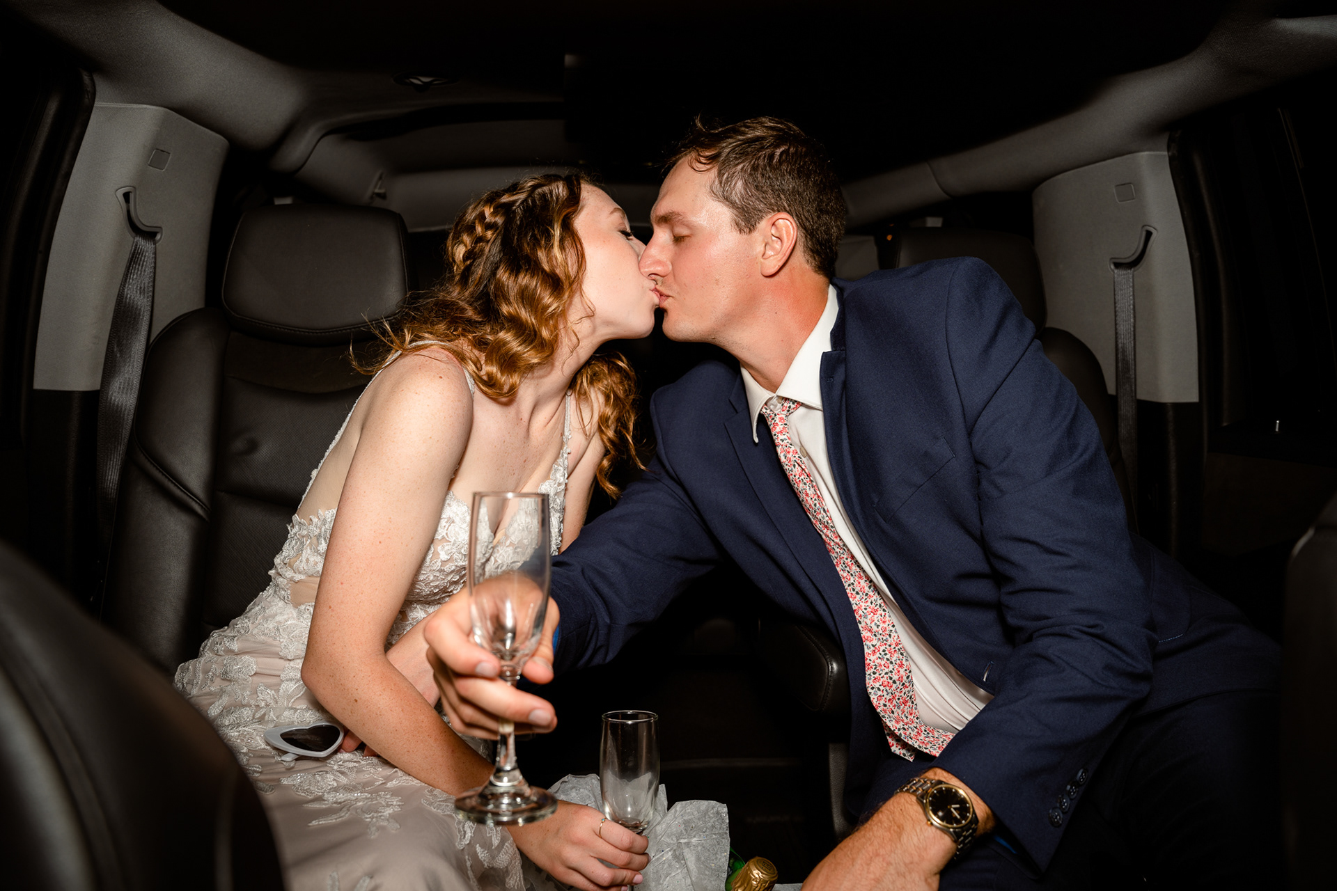 Bride and groom leave wedding in limo with champagne 