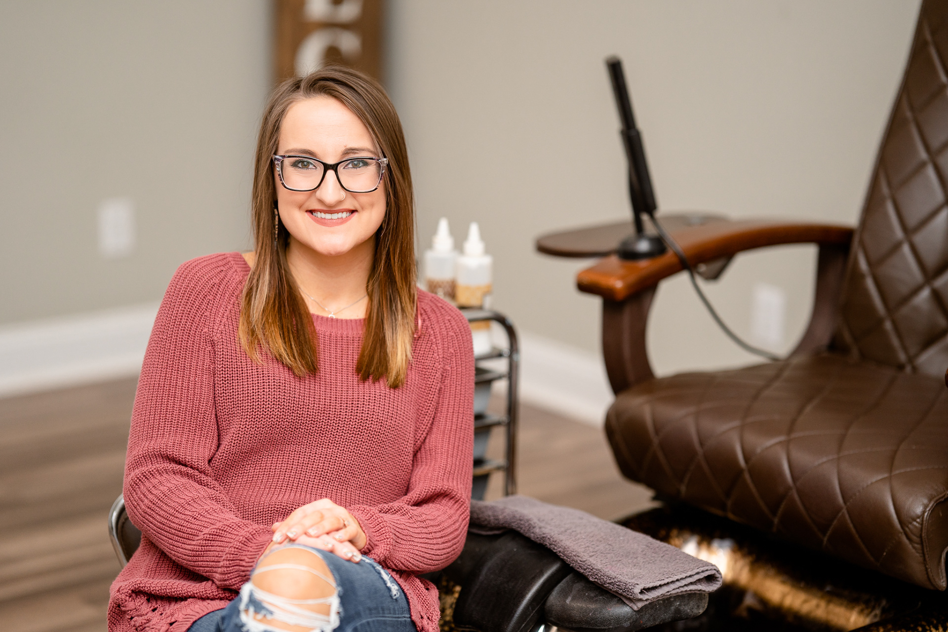 Business owner and nail tech next to her pedicure station