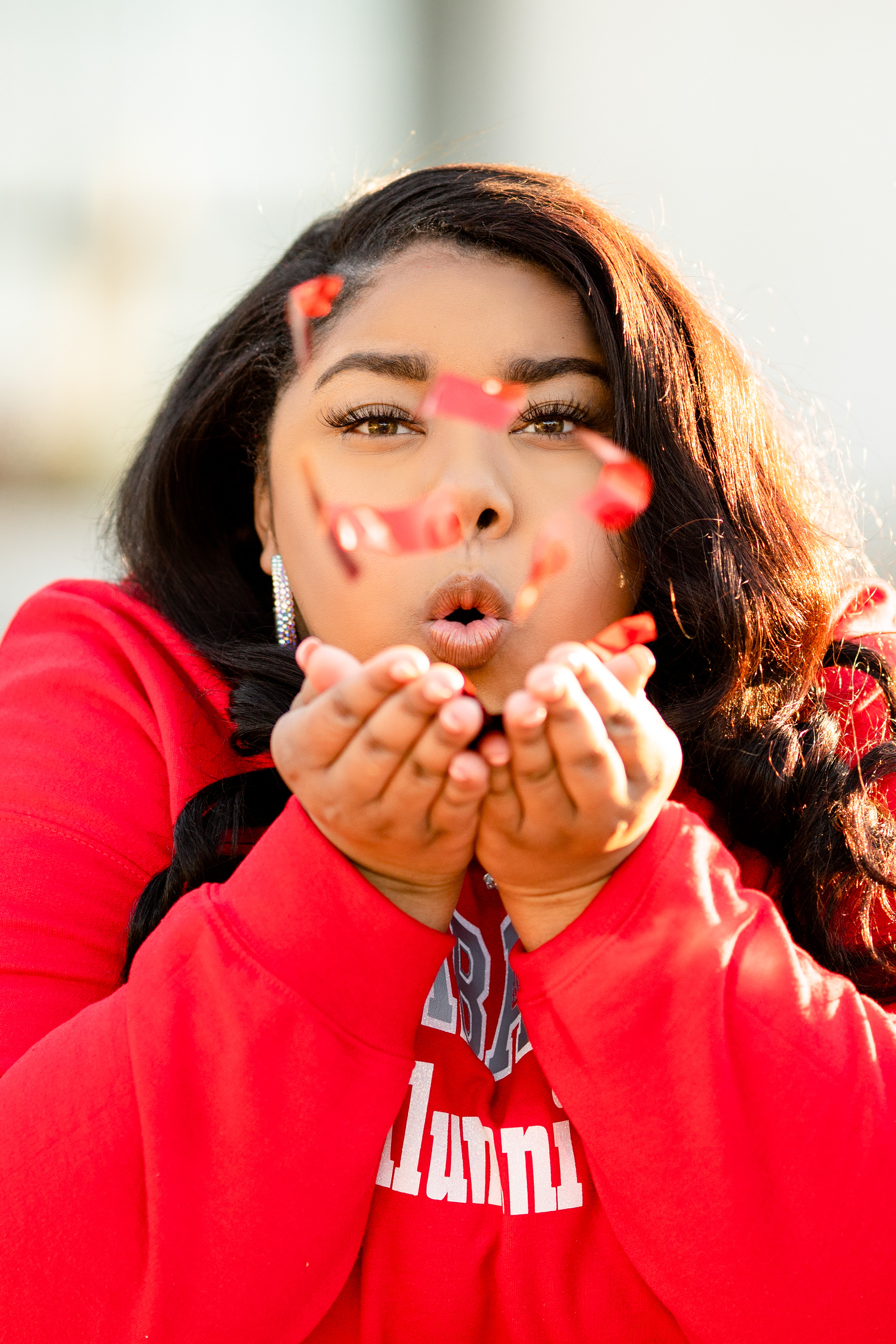 Senior blows confetti at camera