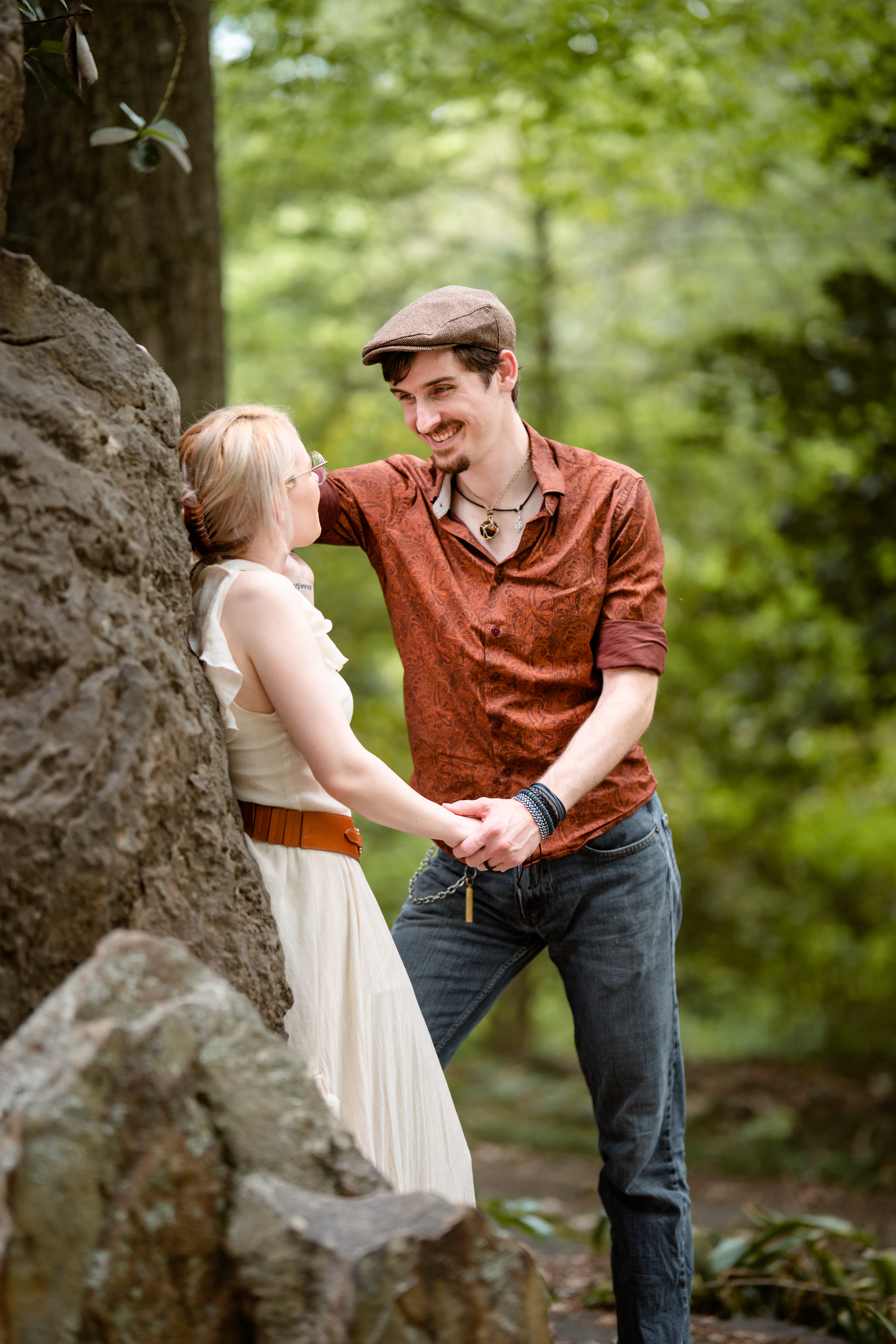 Man looks adoringly at his fiancé in the woods