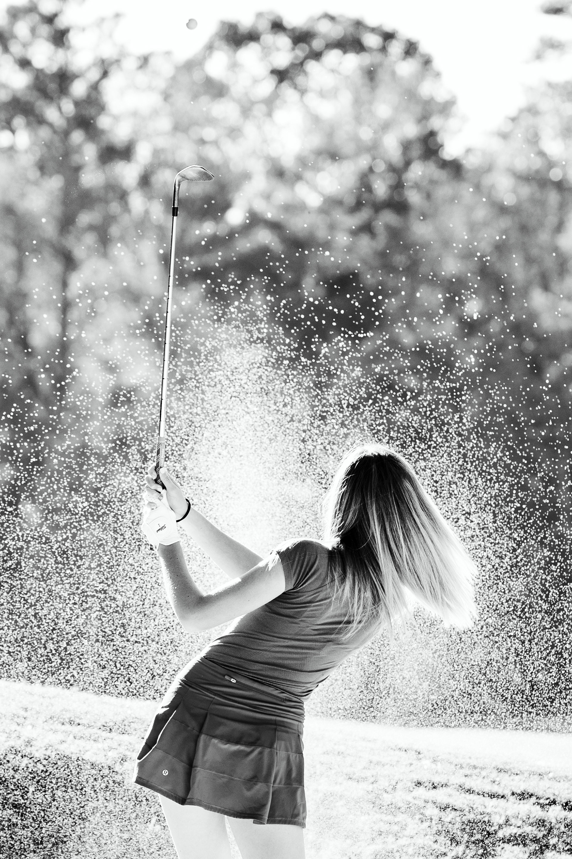 Black and white of golf ball being hit from sand pit