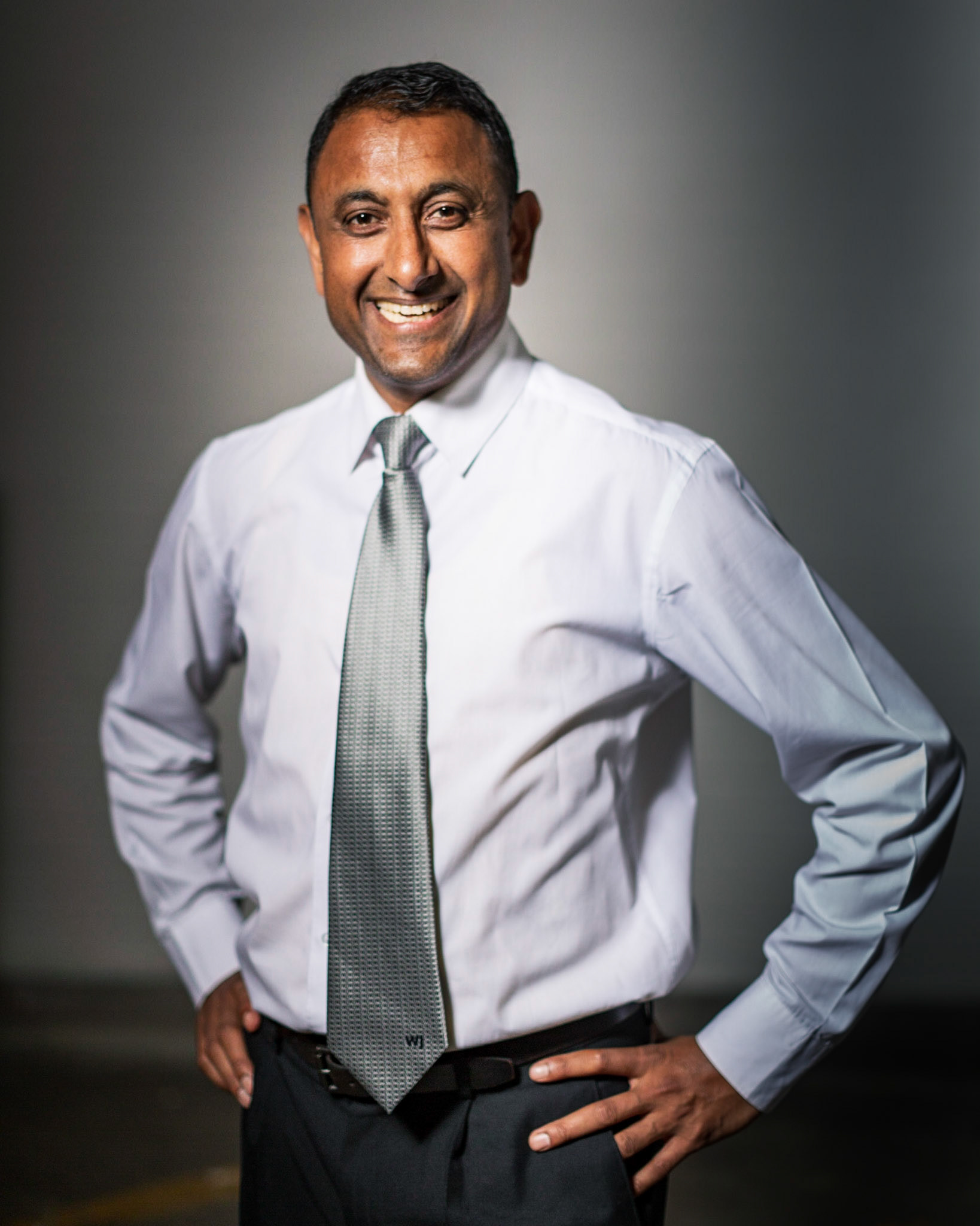 A studio portrait of a confident yet friendly man.
